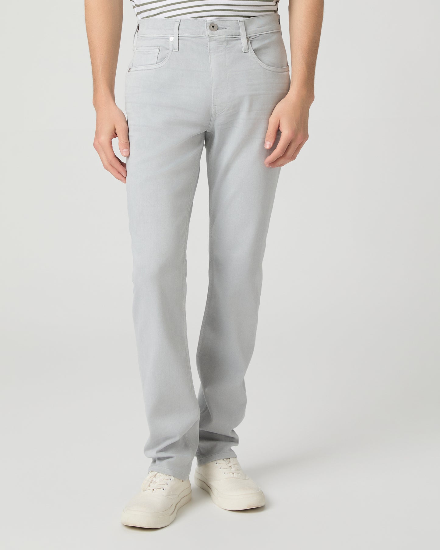 Man wearing a striped shirt and light gray pants on a white background