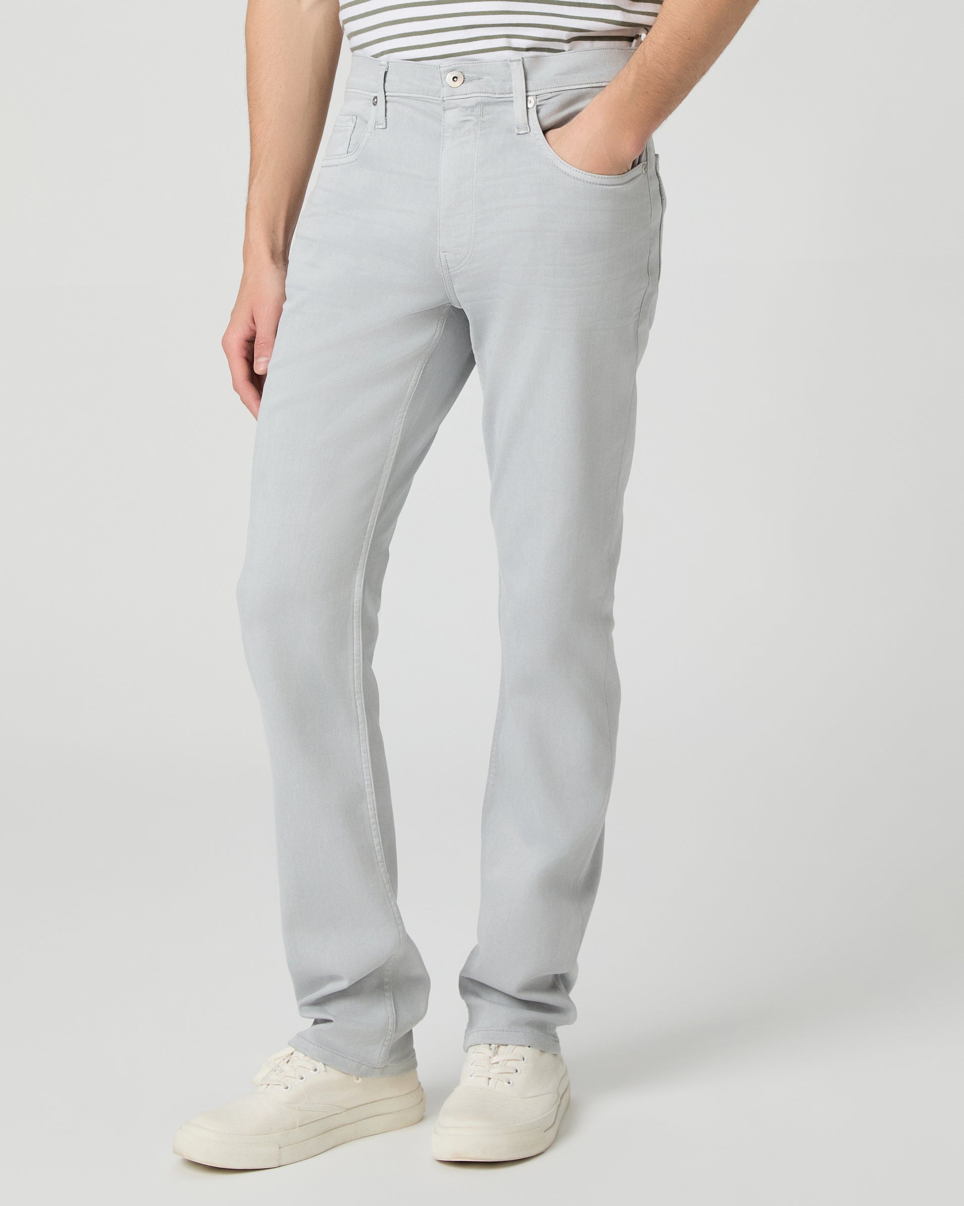 Man wearing a striped shirt and light gray pants on a white background