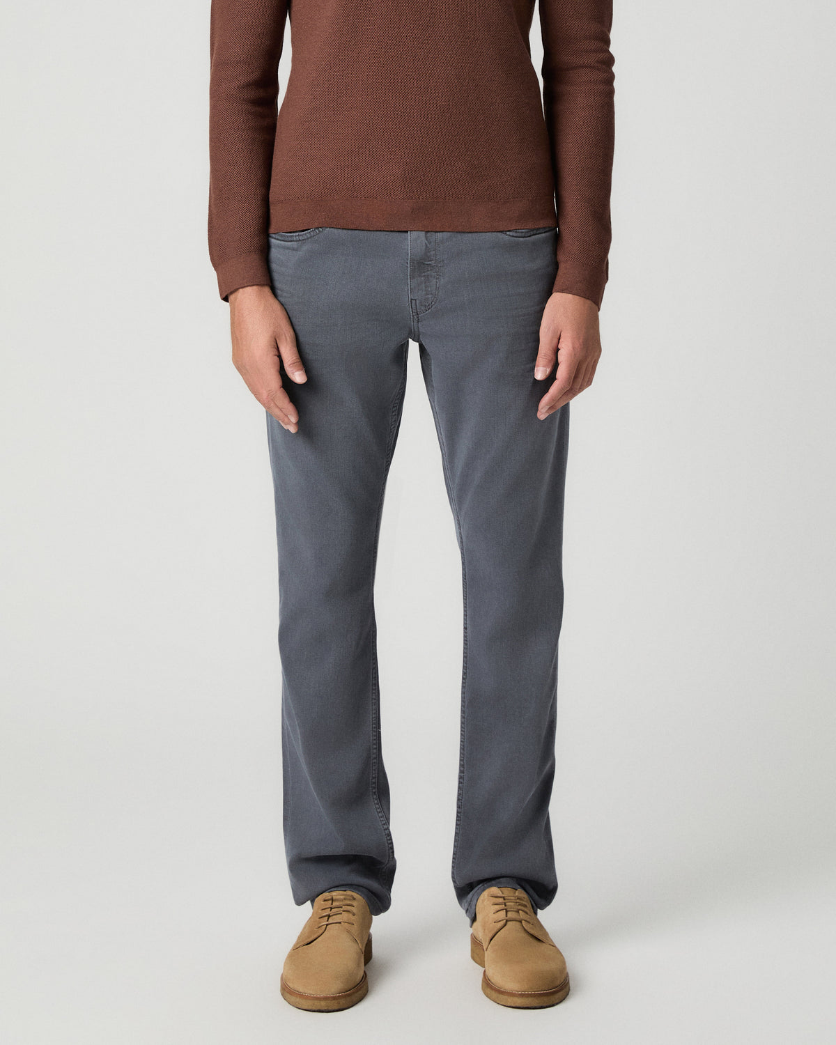Front view from the waist down of the Federal 32 Inch Slim Straight Jean in Vintage Icy River, a grey wash, worn with a reddish-brown knit polo and tan suede boots