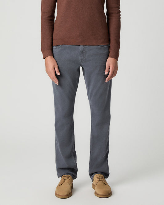Front view from the waist down of the Federal 32 Inch Slim Straight Jean in Vintage Icy River, a grey wash, worn with a reddish-brown knit polo and tan suede boots
