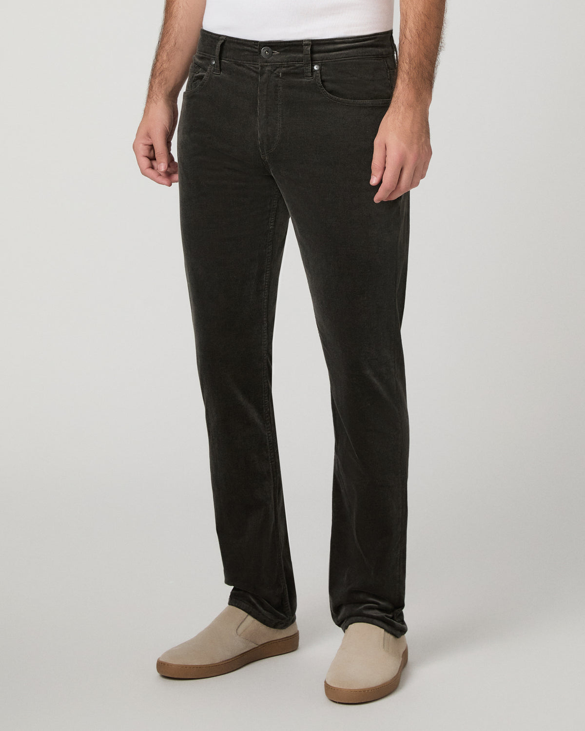 Man wearing white top and black pants against a white background