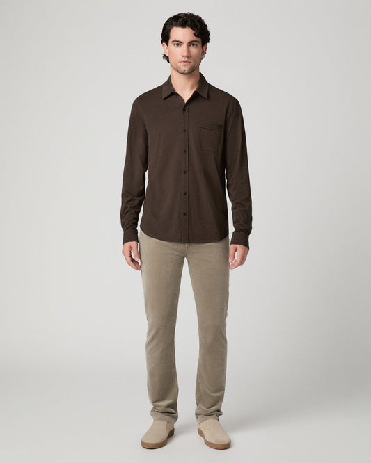 Man wearing brown top and beige pants against a white background