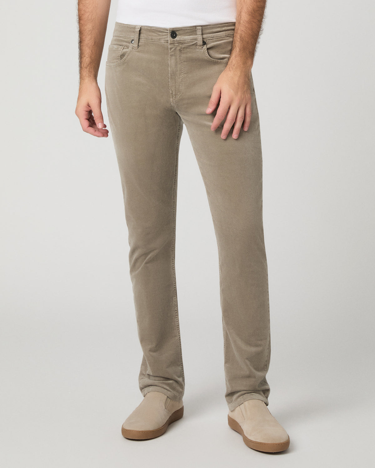Man wearing white top and beige pants against a white background