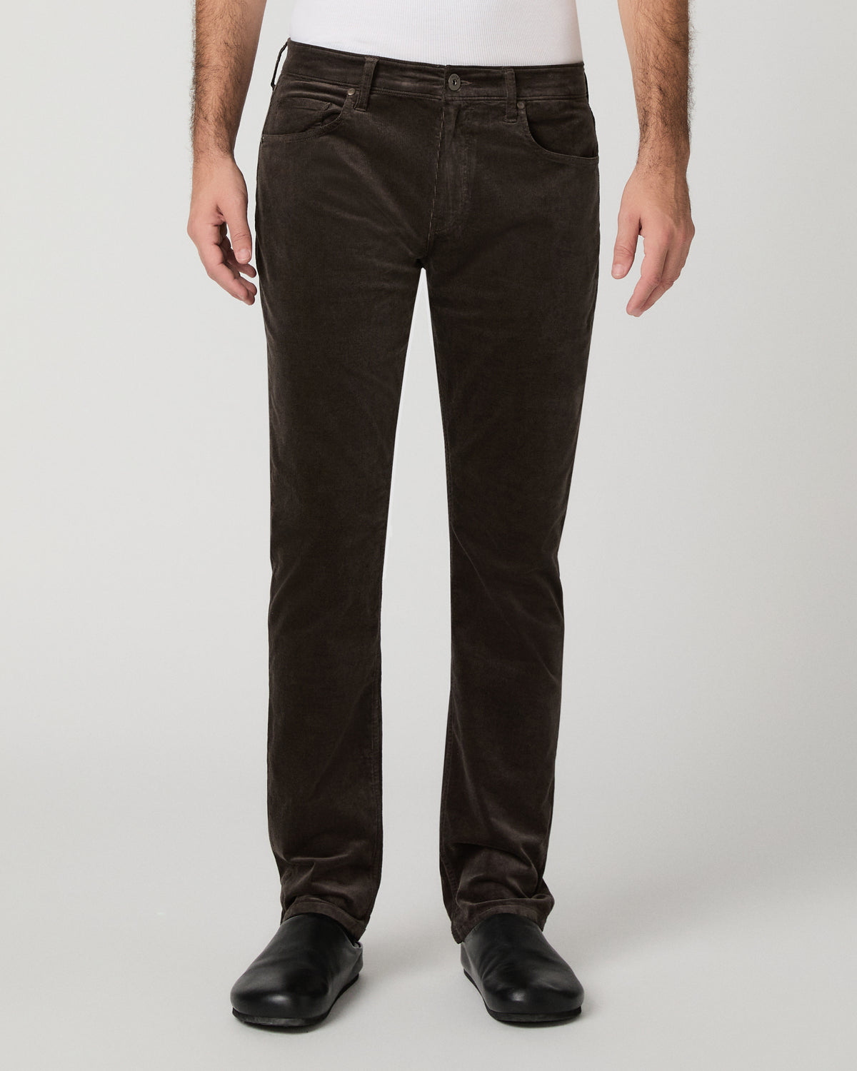 Man wearing brown shirt and brown pants against a white background