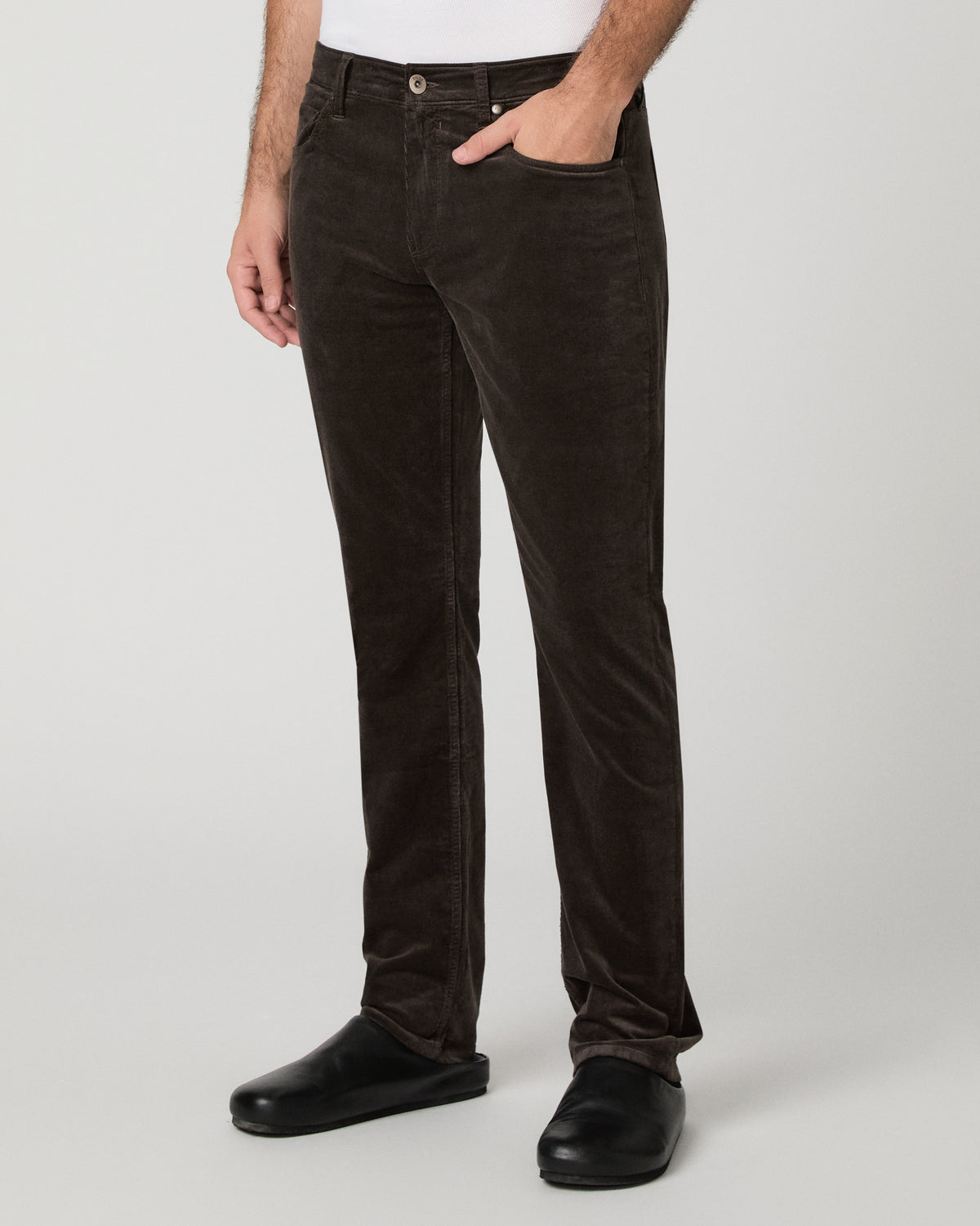 Man wearing brown shirt and brown pants against a white background