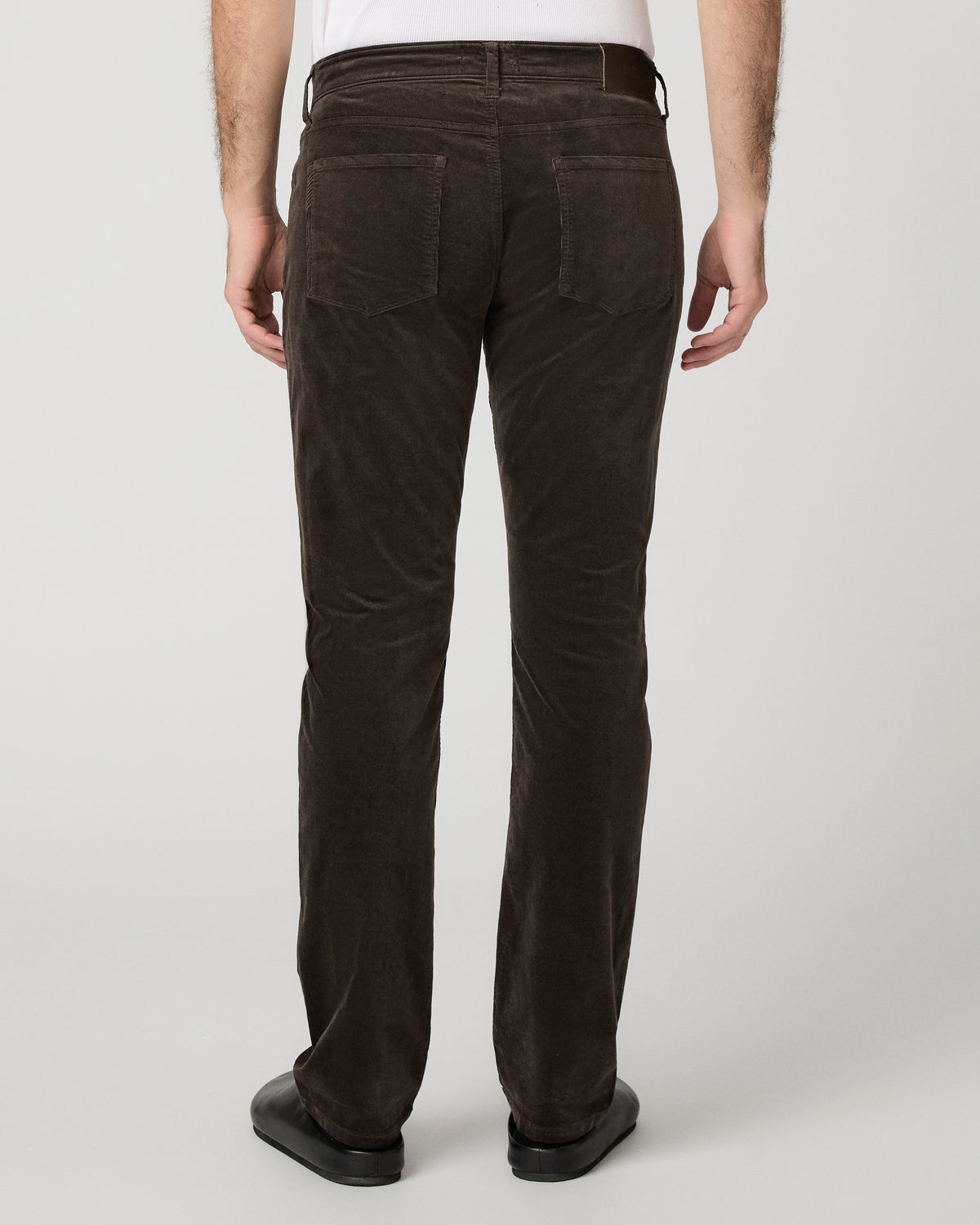 Man wearing brown shirt and brown pants against a white background