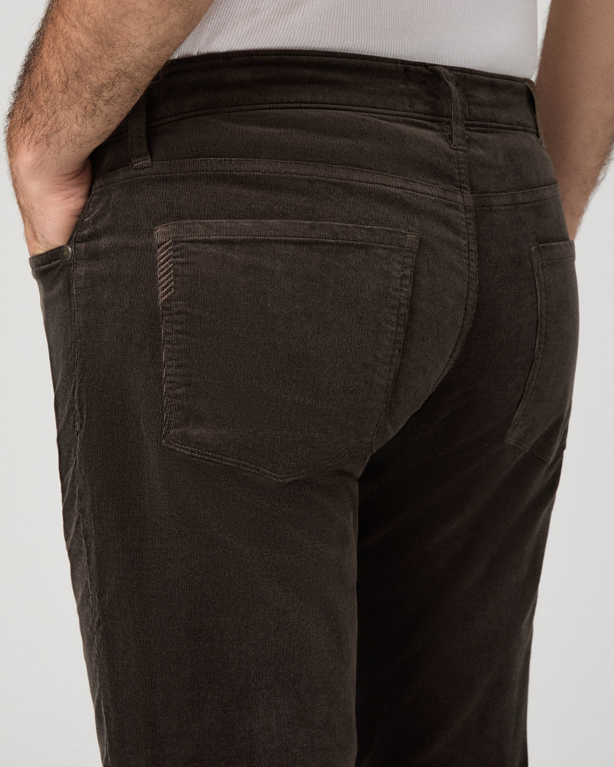 Man wearing brown shirt and brown pants against a white background