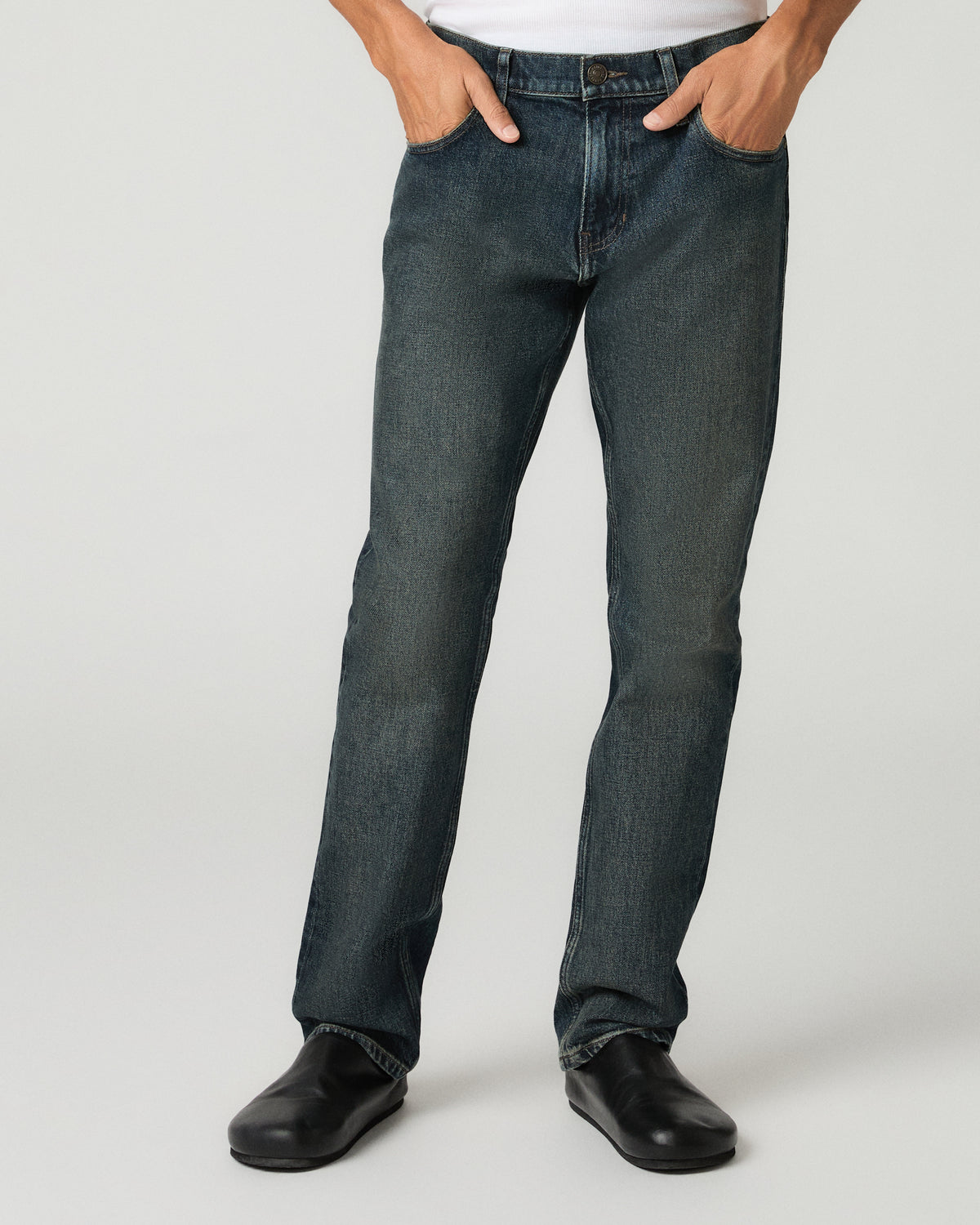 Close-up back view of charcoal slim-straight jeans, showing the back pockets and a white t-shirt above the waistband.