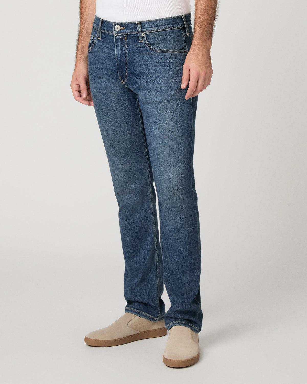 Man wearing beige and blue pants against a white background