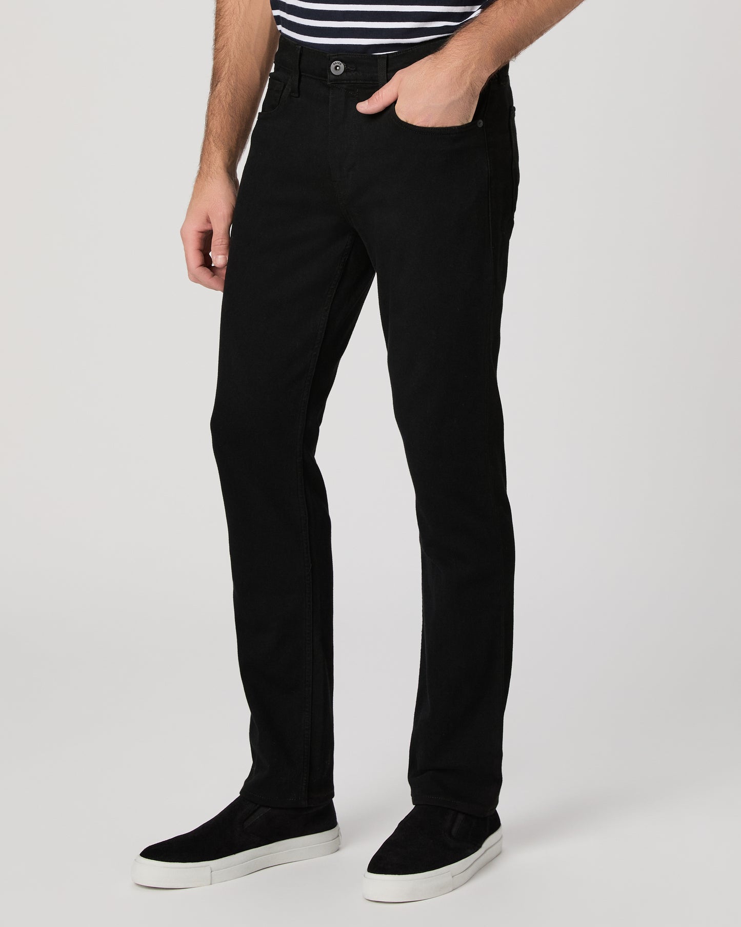 Man wearing a black and white striped shirt and black pants on a white background