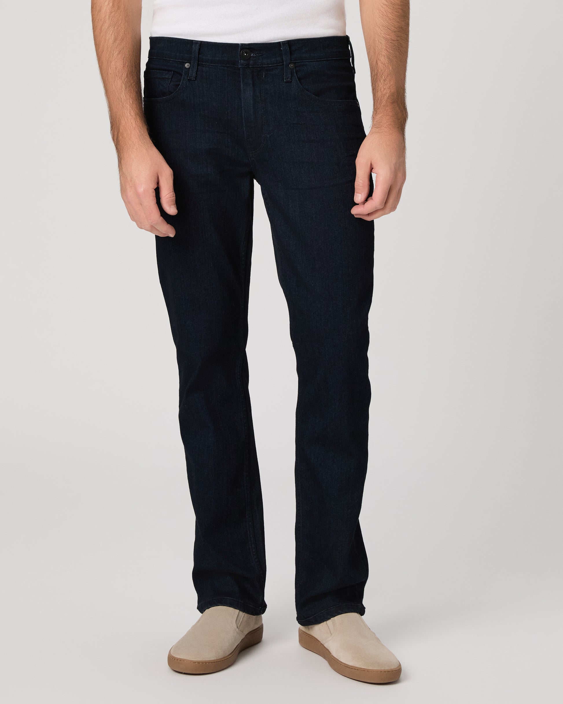 Man wearing a white tee and dark jeans on a white background