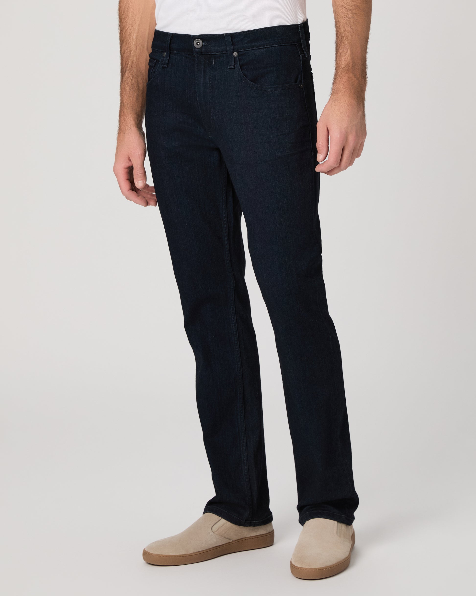 Man wearing a white tee and dark jeans on a white background