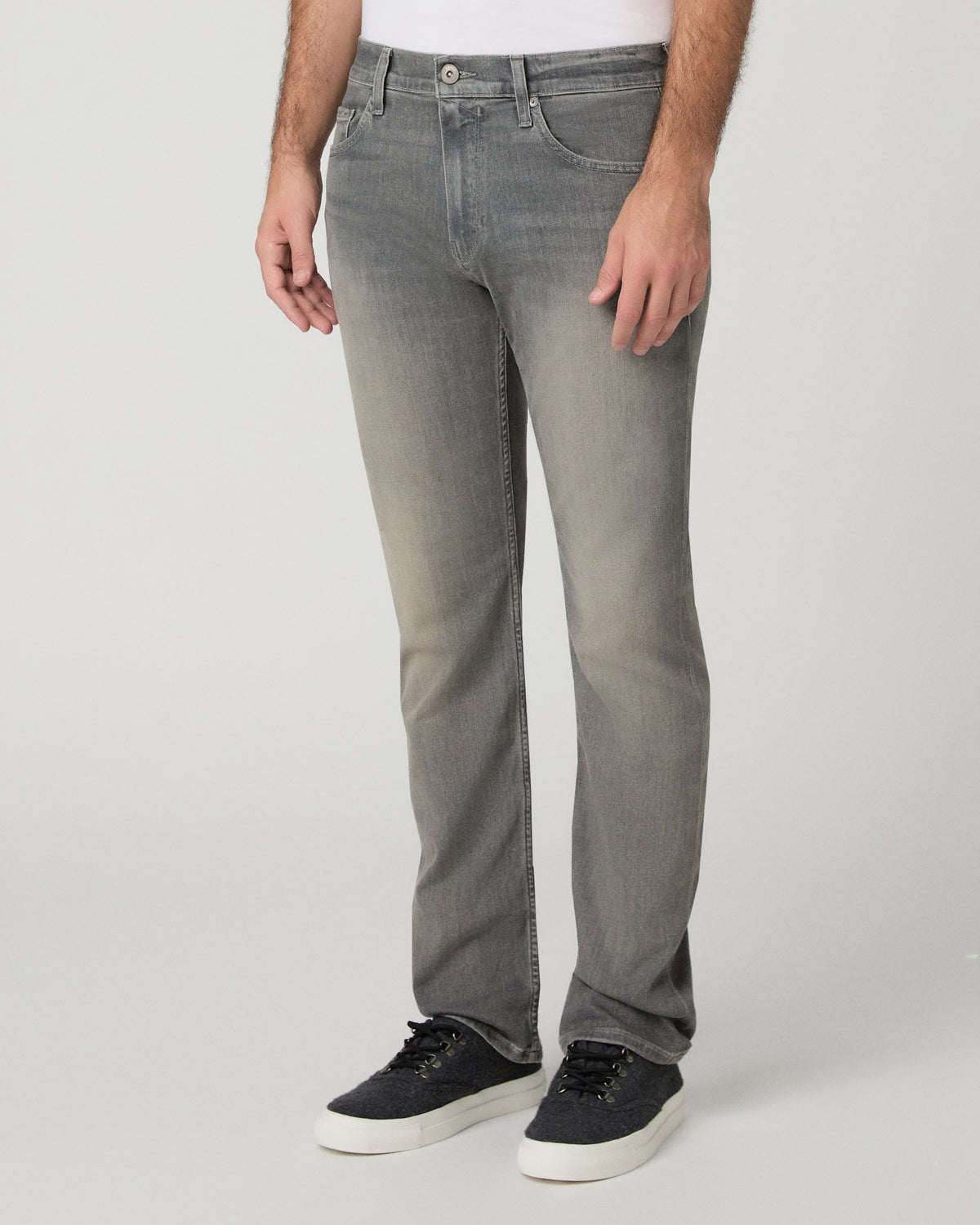 Man wearing white shirt and grey pants against a white background