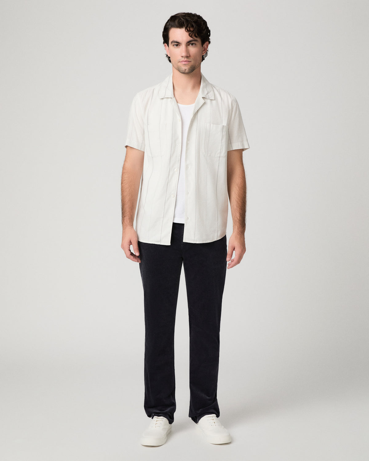 Man wearing white shirt and blue pants against a white background