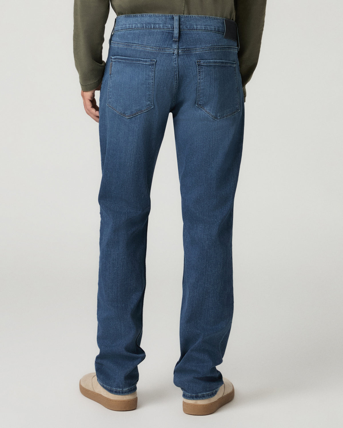 Rear full-length view from the waist down showing the classic straight fit of the medium blue wash denim through the seat and leg.