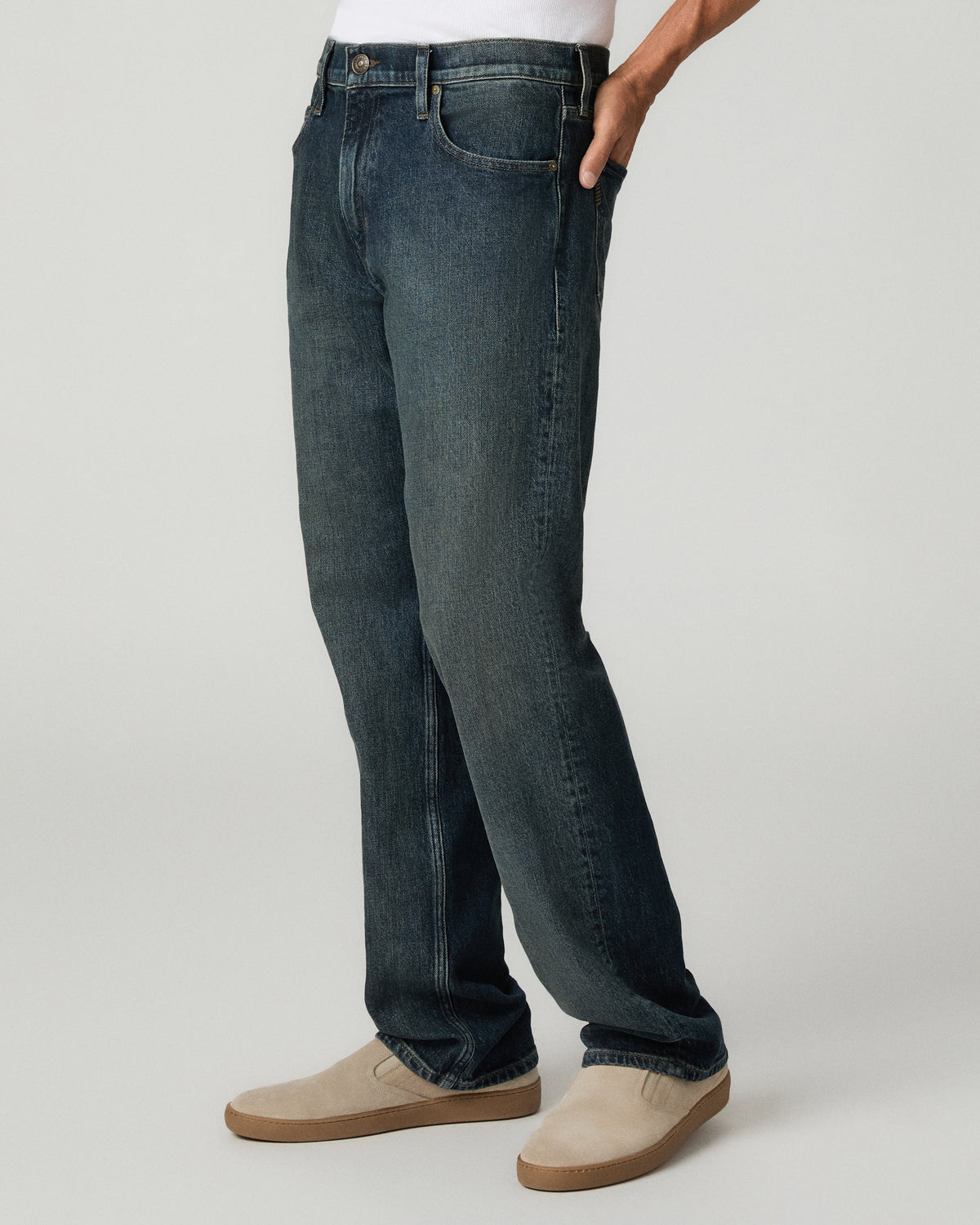Angled three-quarter view from the waist down with one hand tucked in the pocket, highlighting the relaxed straight leg silhouette and heavy contrast fading of the denim.