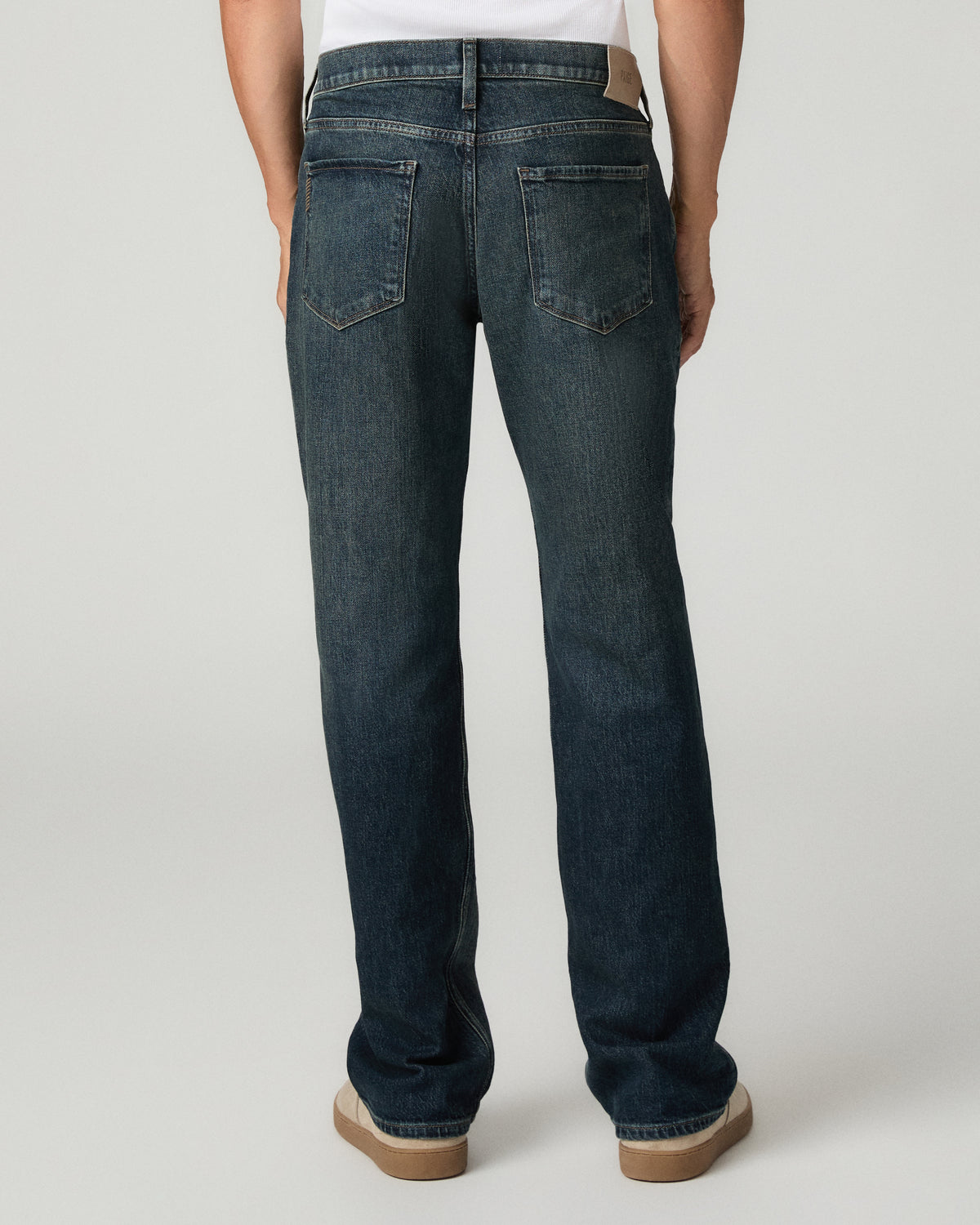 Rear full-length view from the waist down of the dark wash relaxed straight jeans, showing the straight leg opening and fading down the back of the thigh.
