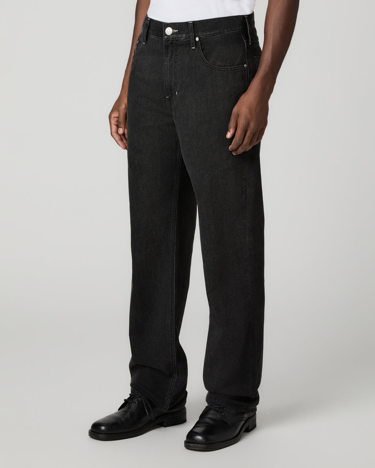 Angled three-quarter front view from the waist down showing the relaxed straight leg silhouette in the charcoal-black wash.
