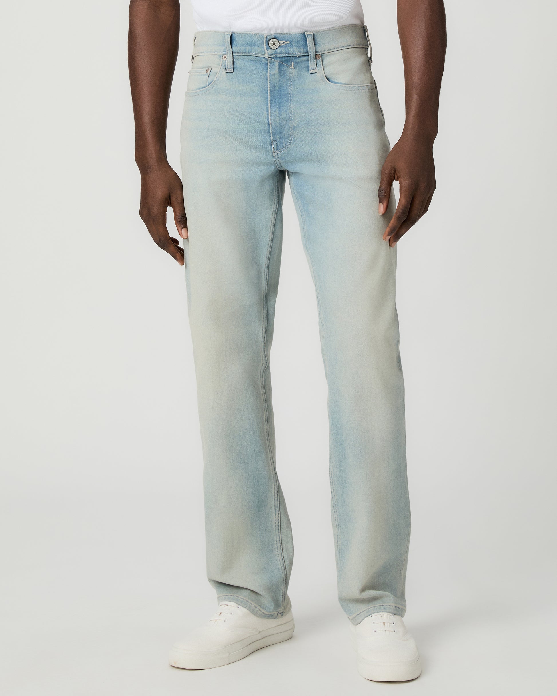 Man wearing a white tee and light blue jeans on a white background