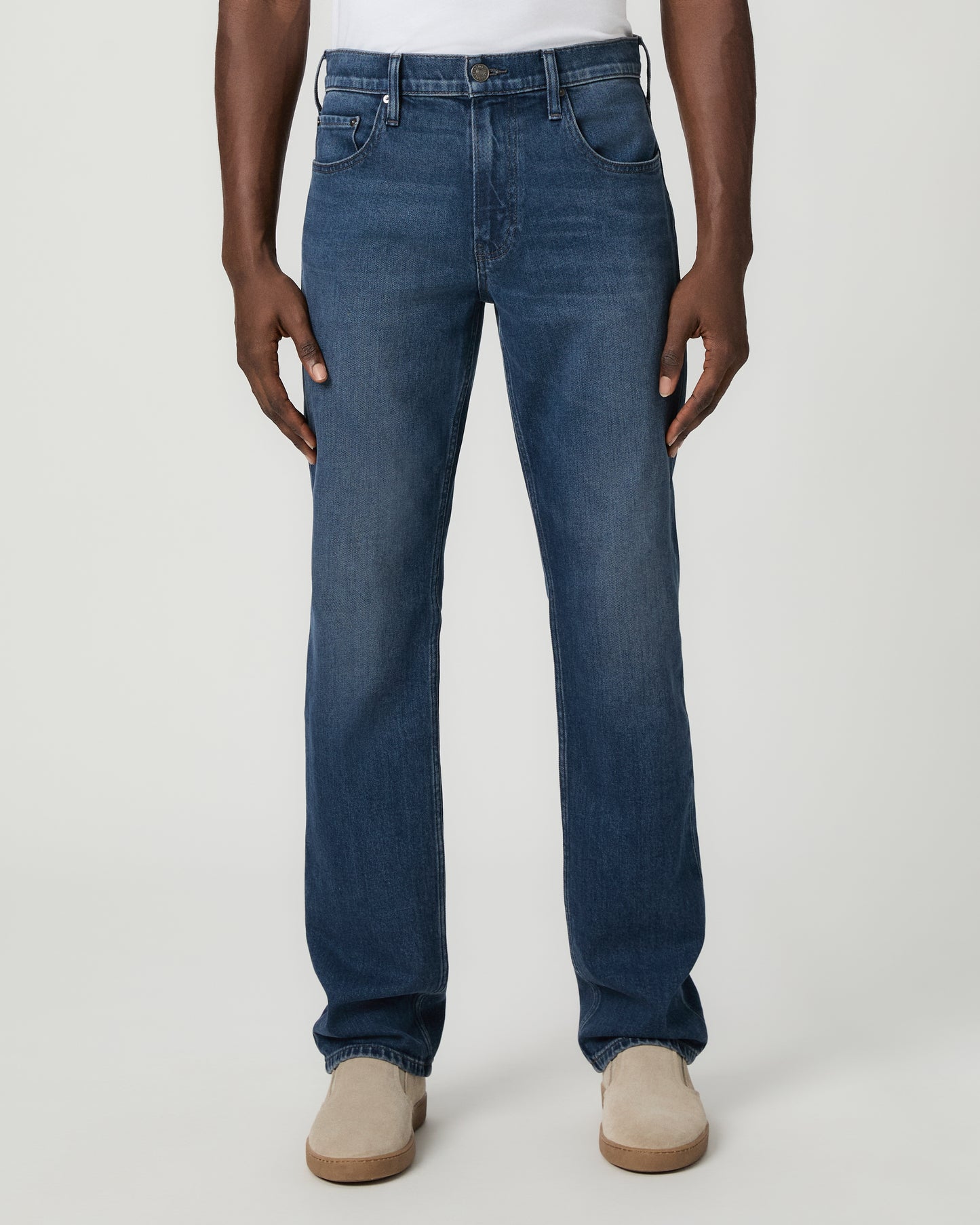 Man wearing a white shirt, and blue jeans on a white background