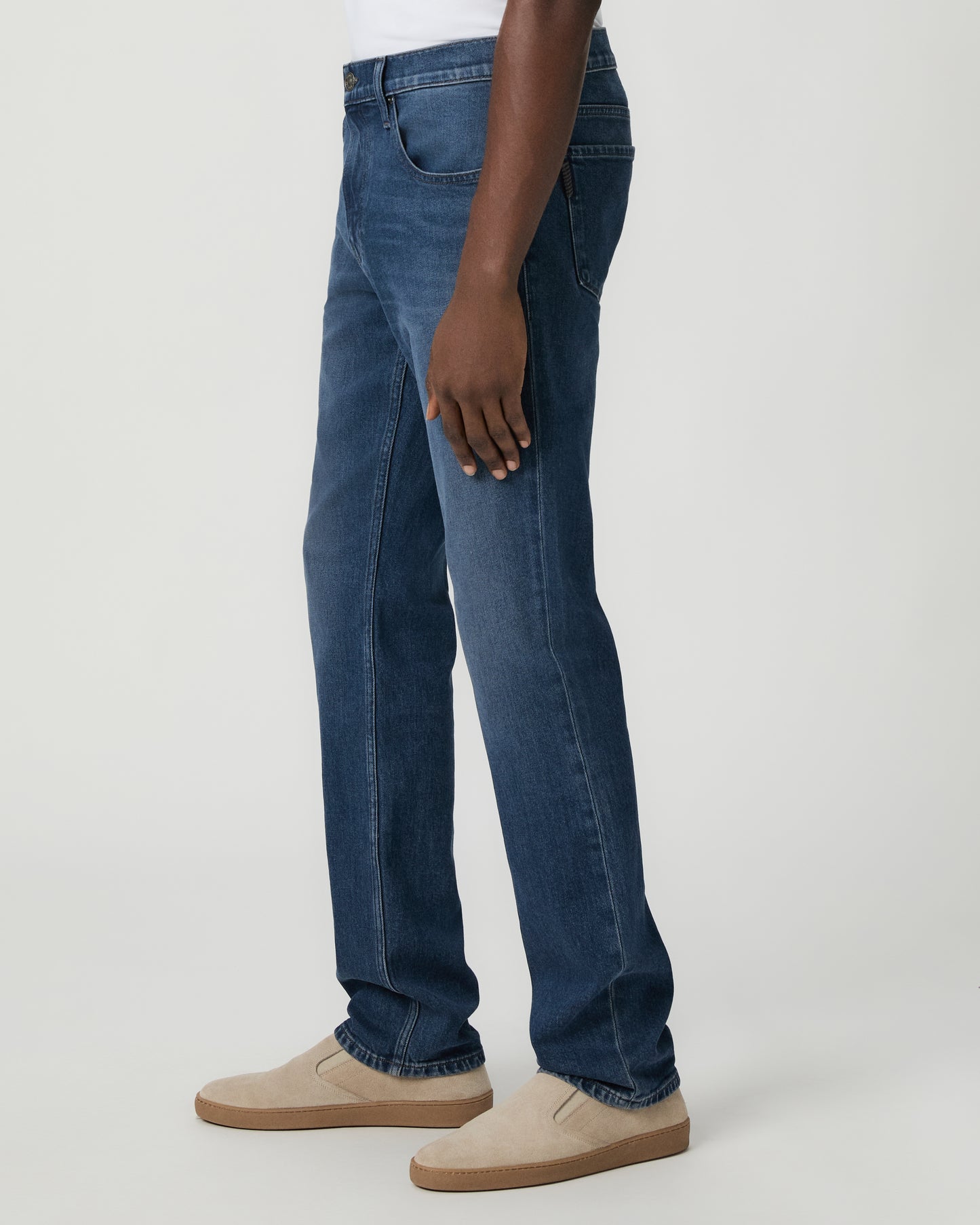 Man wearing a white shirt, and blue jeans on a white background