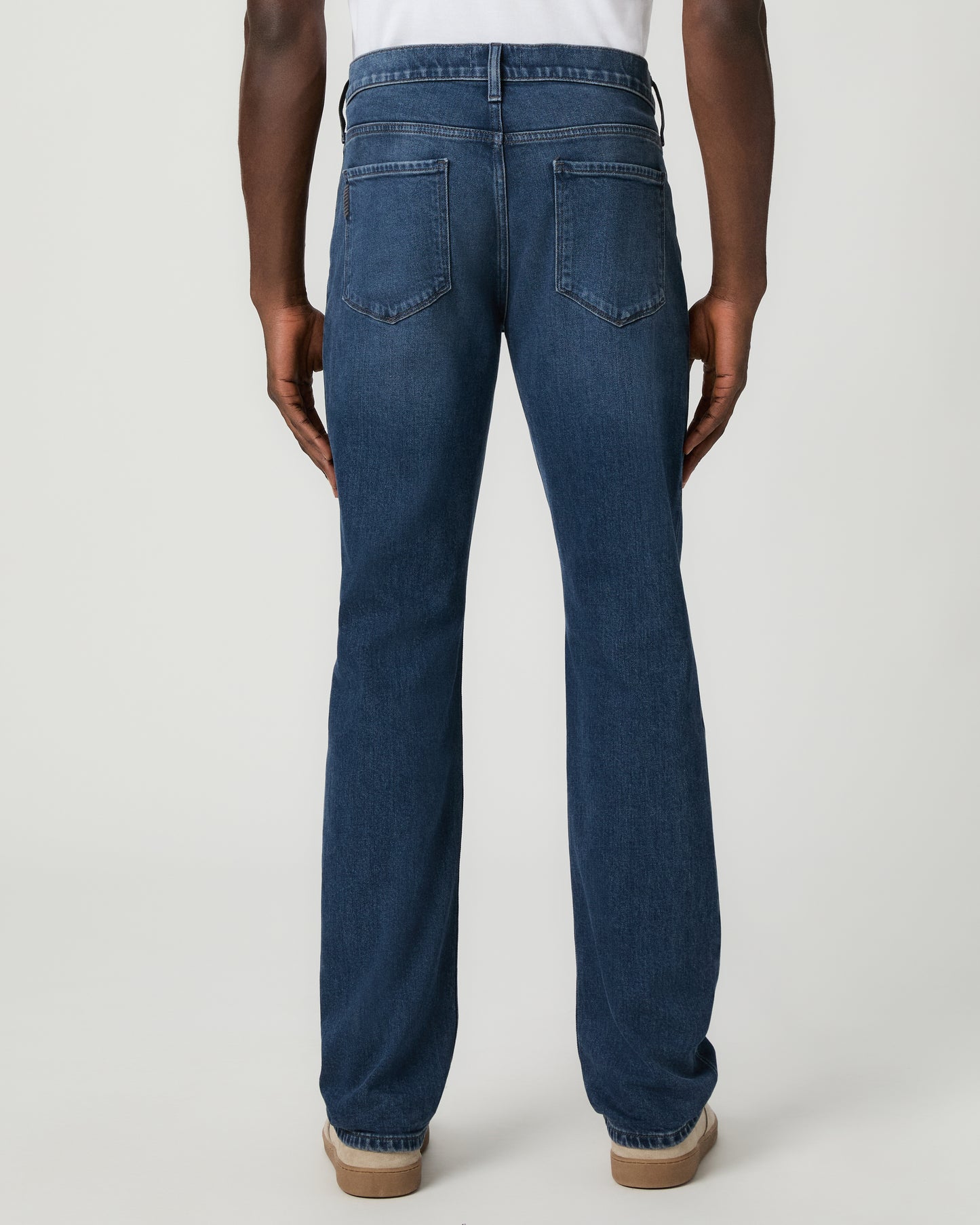 Man wearing a white shirt, and blue jeans on a white background