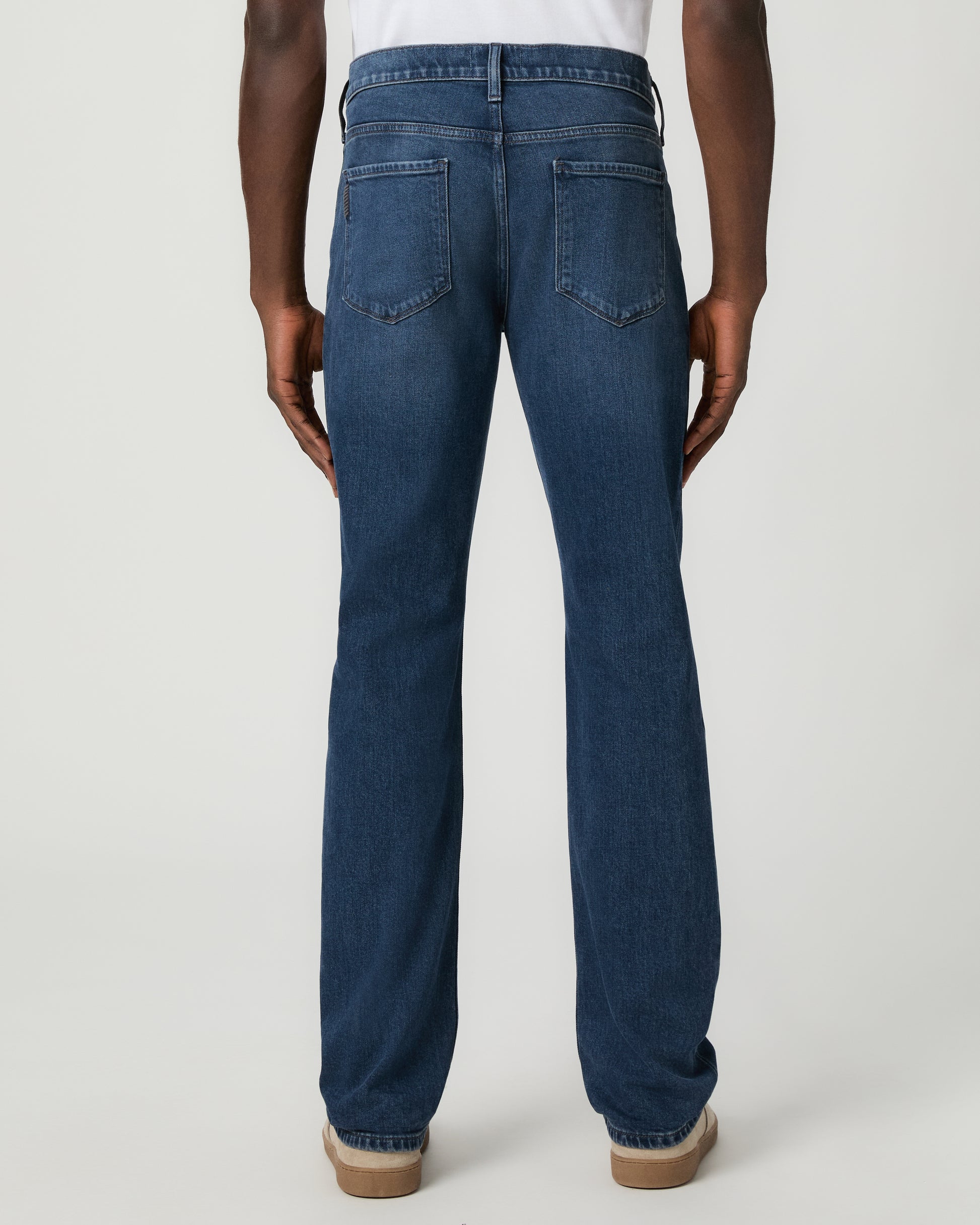 Man wearing a white shirt, and blue jeans on a white background