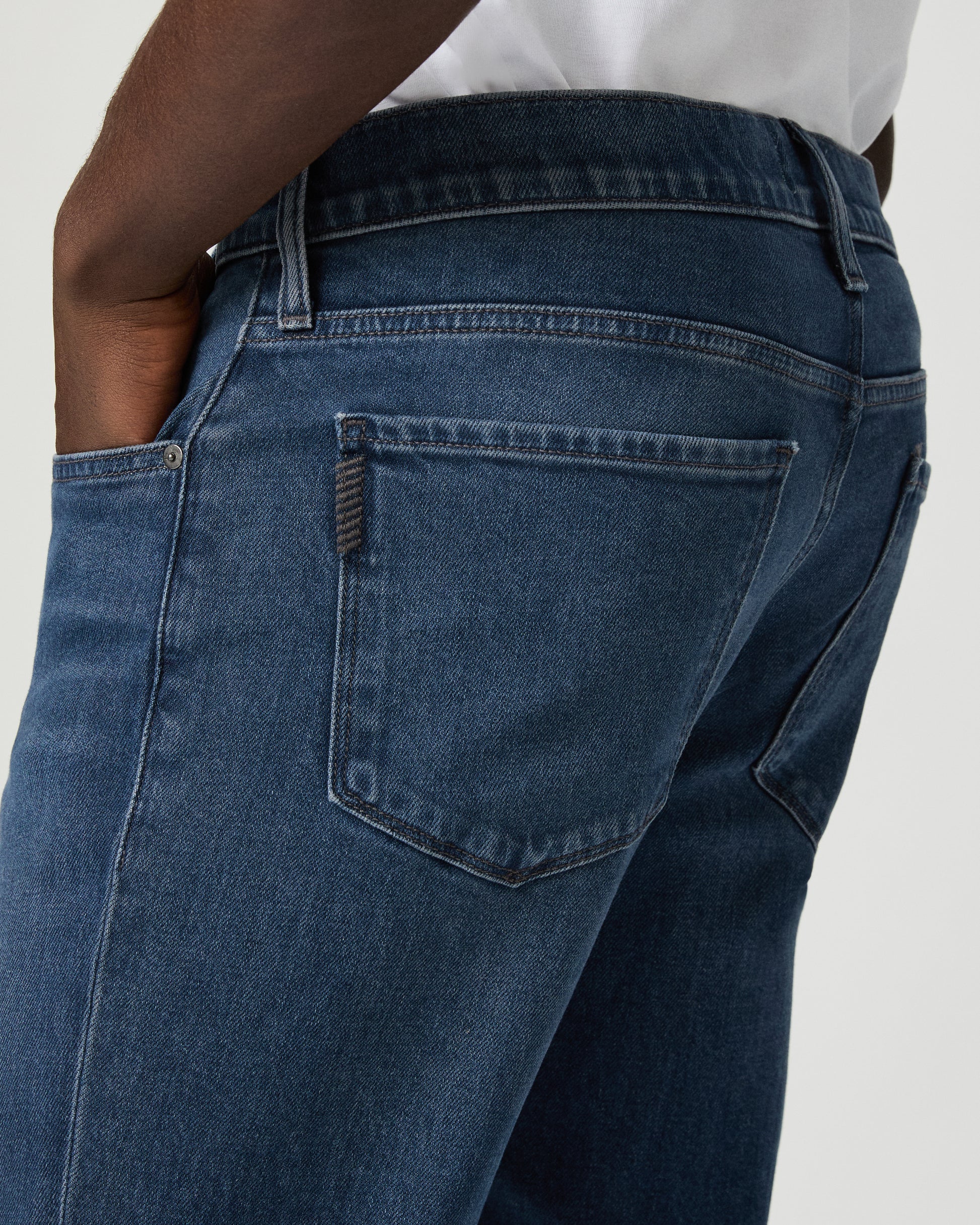 Man wearing a white shirt, and blue jeans on a white background