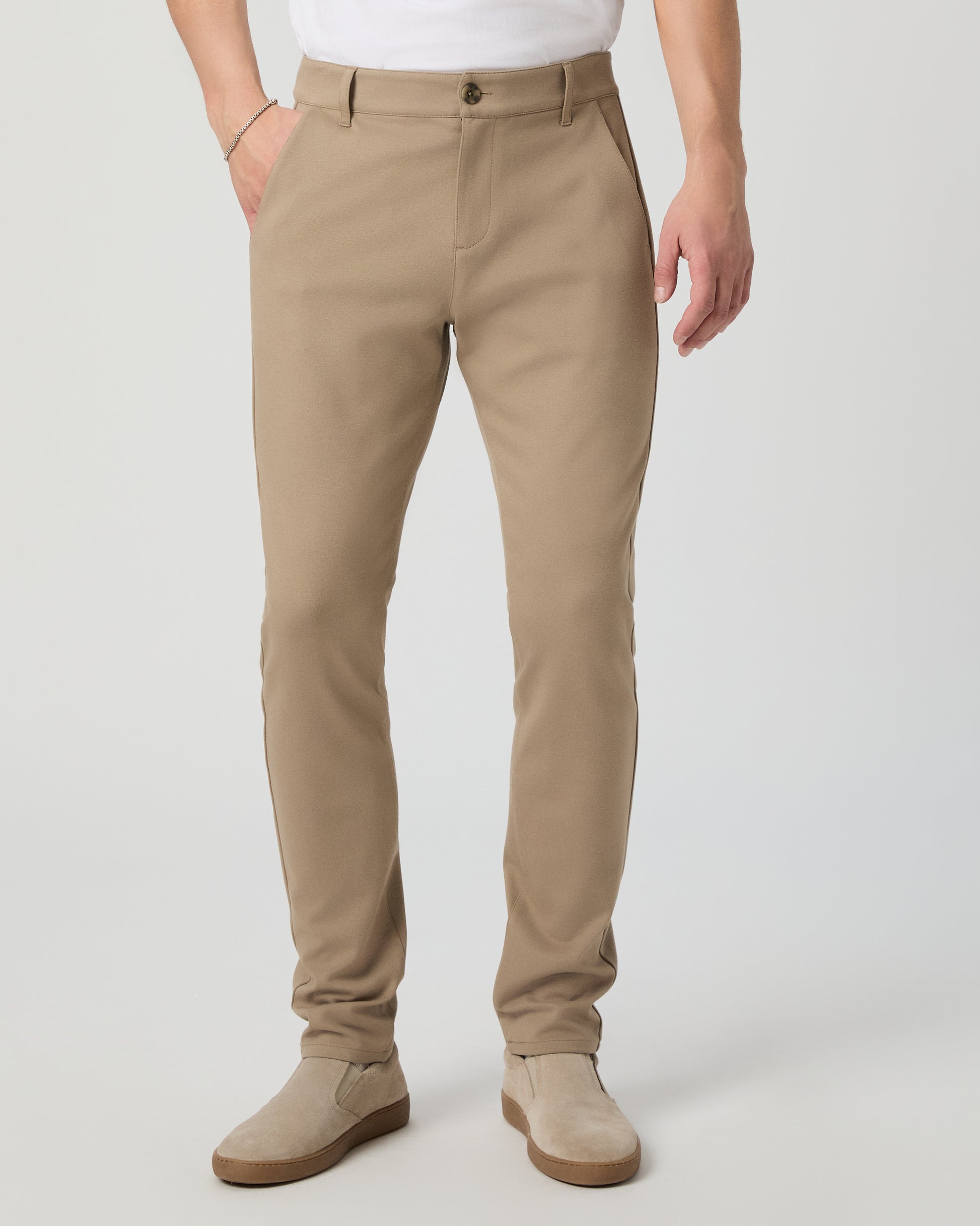 Man wearing a white tee and beige pants on a white background