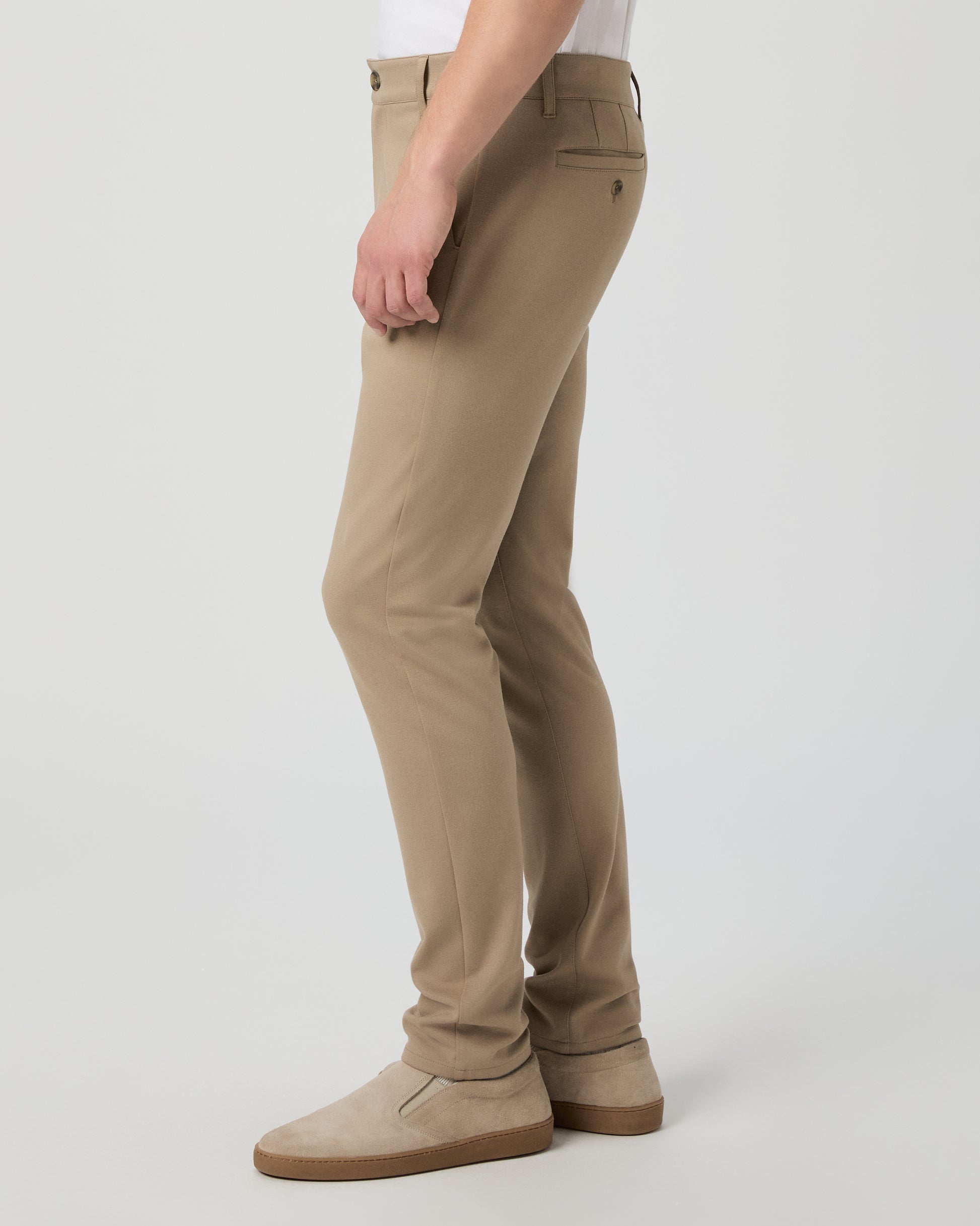 Man wearing a white tee and beige pants on a white background