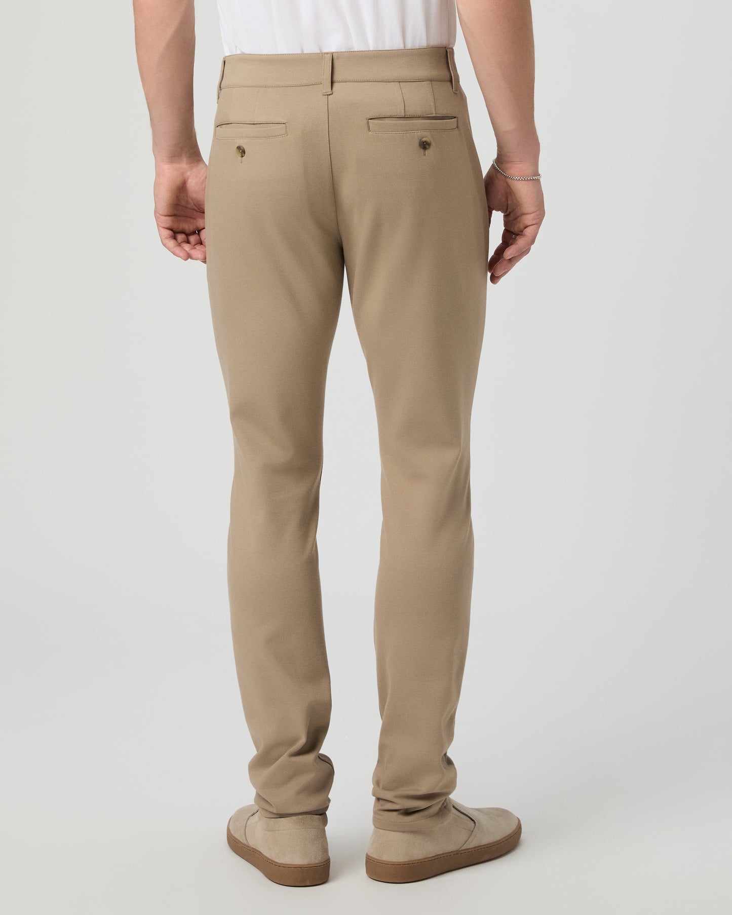 Man wearing a white tee and beige pants on a white background
