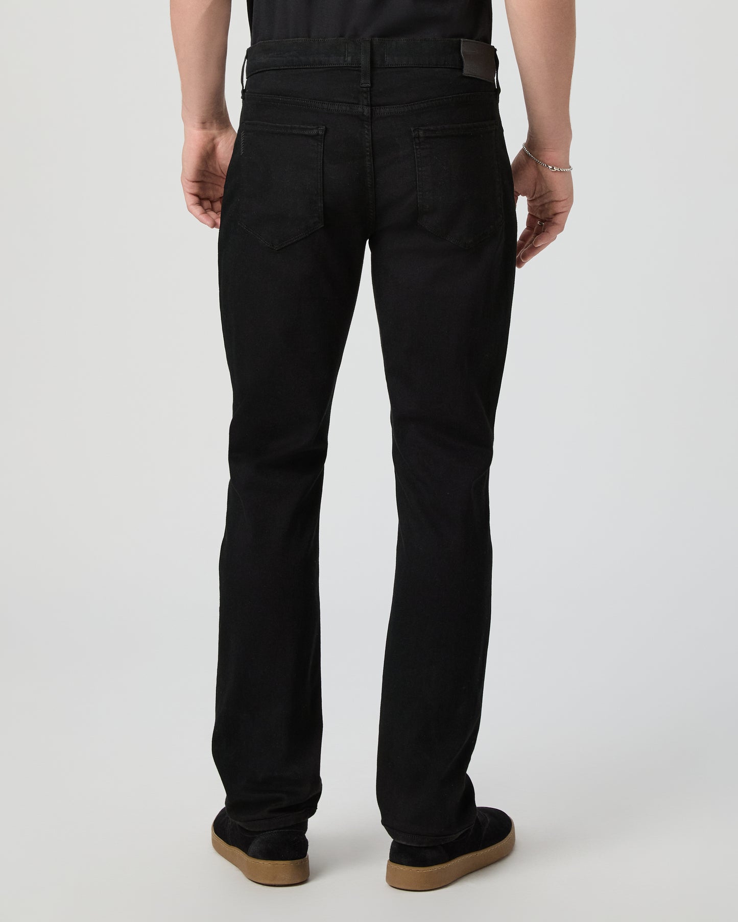 Man wearing a black tee and black pants on a white background