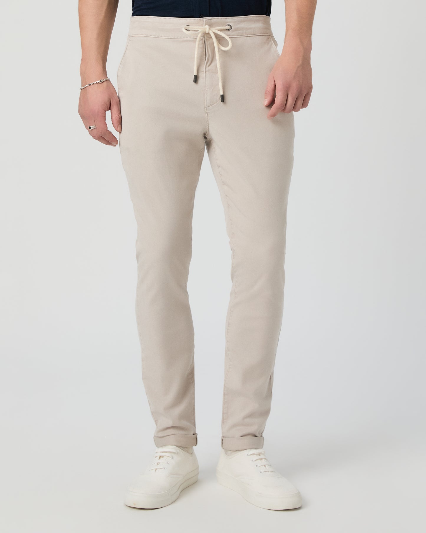 Person wearing beige sweatpants on a white background