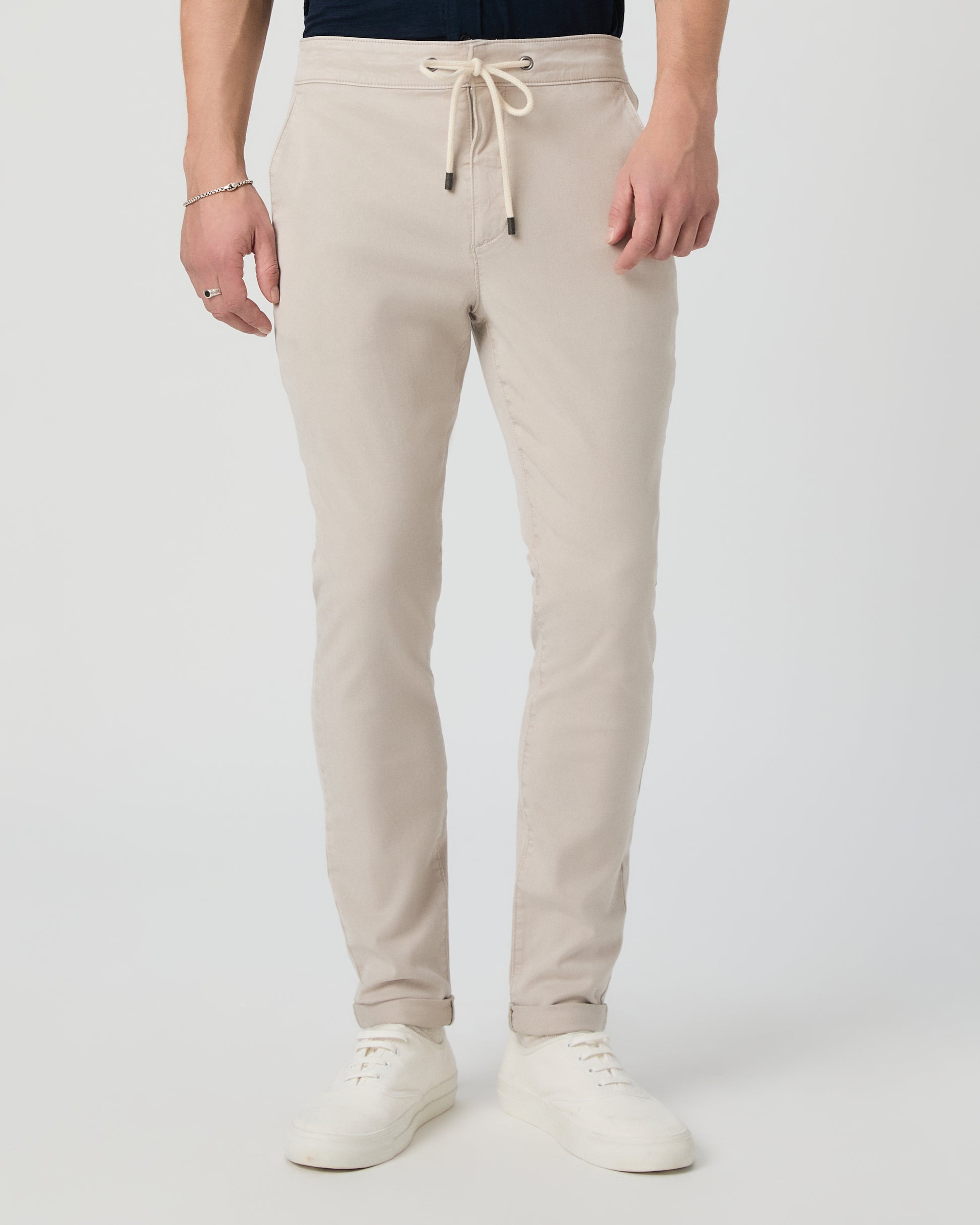 Person wearing beige sweatpants on a white background