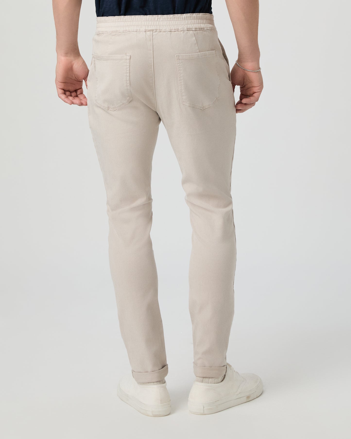 Person wearing beige pants on a white background