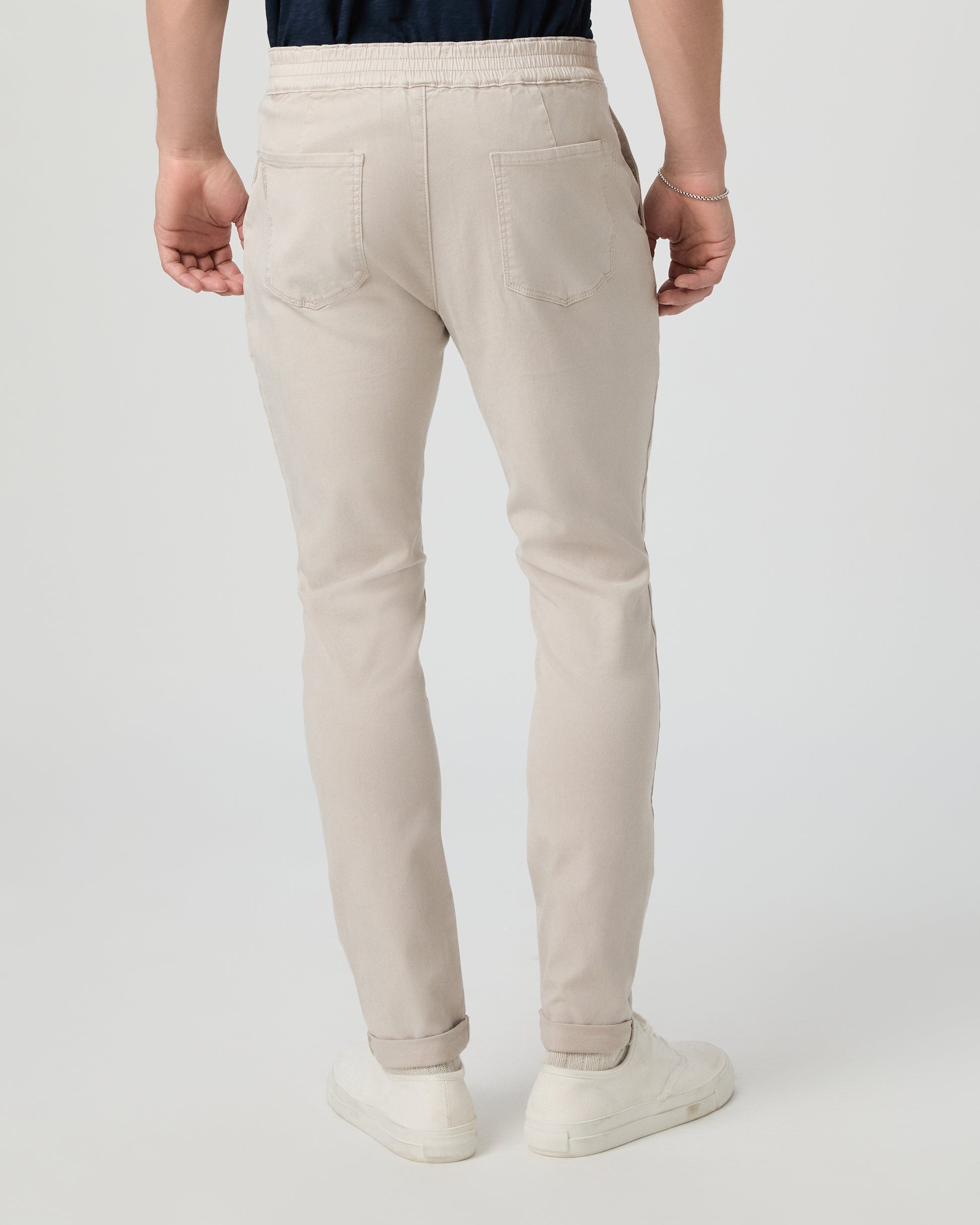 Person wearing beige pants on a white background