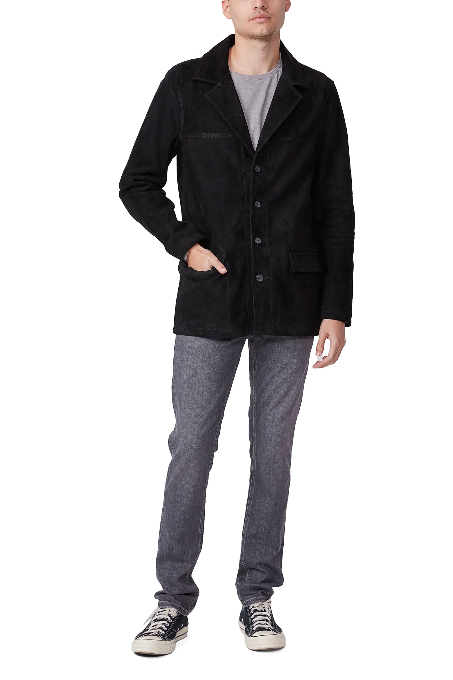 Person wearing a black coat, gray pants, and black shoes on a white background
