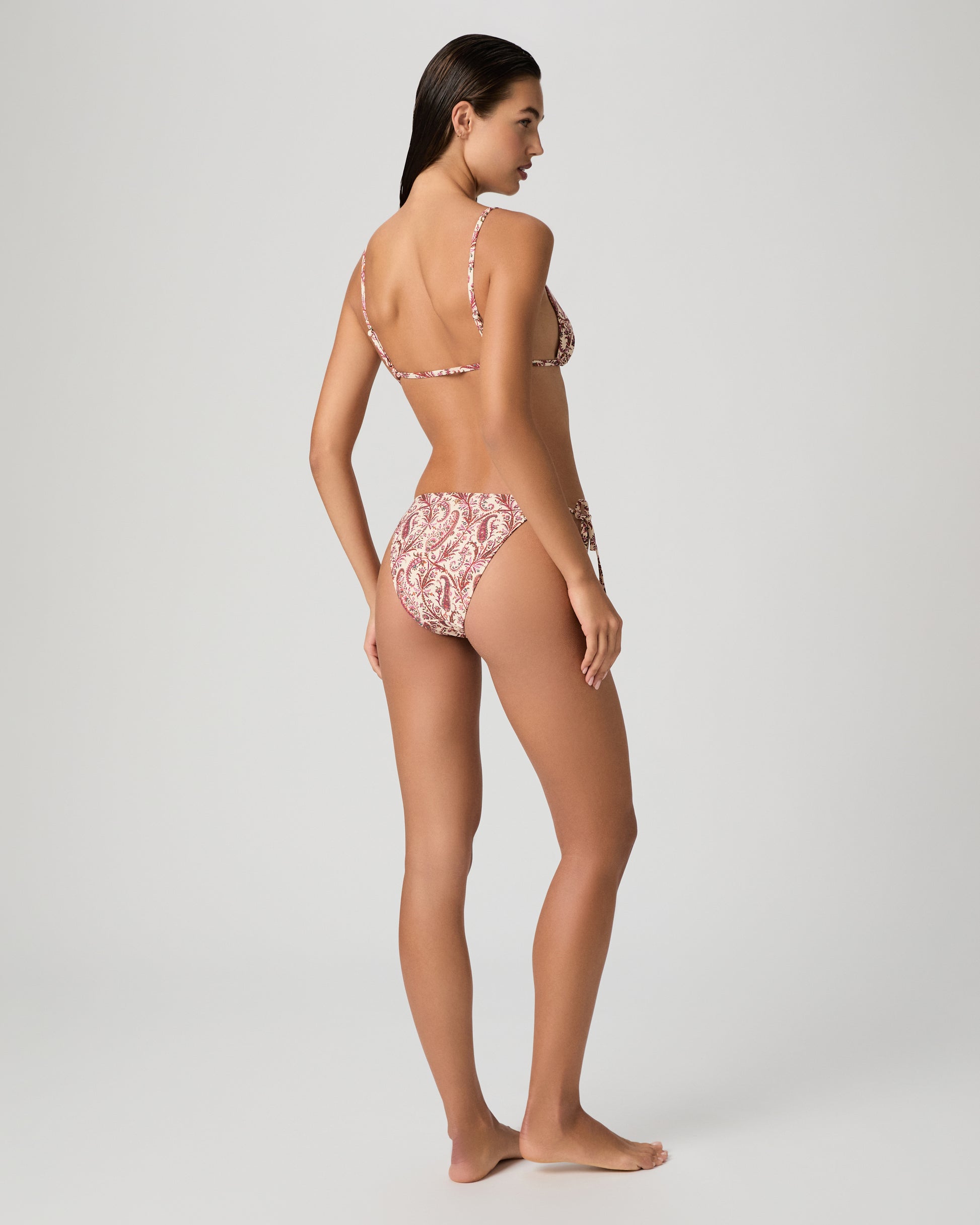 Woman wearing a pink floral bikini on a white background