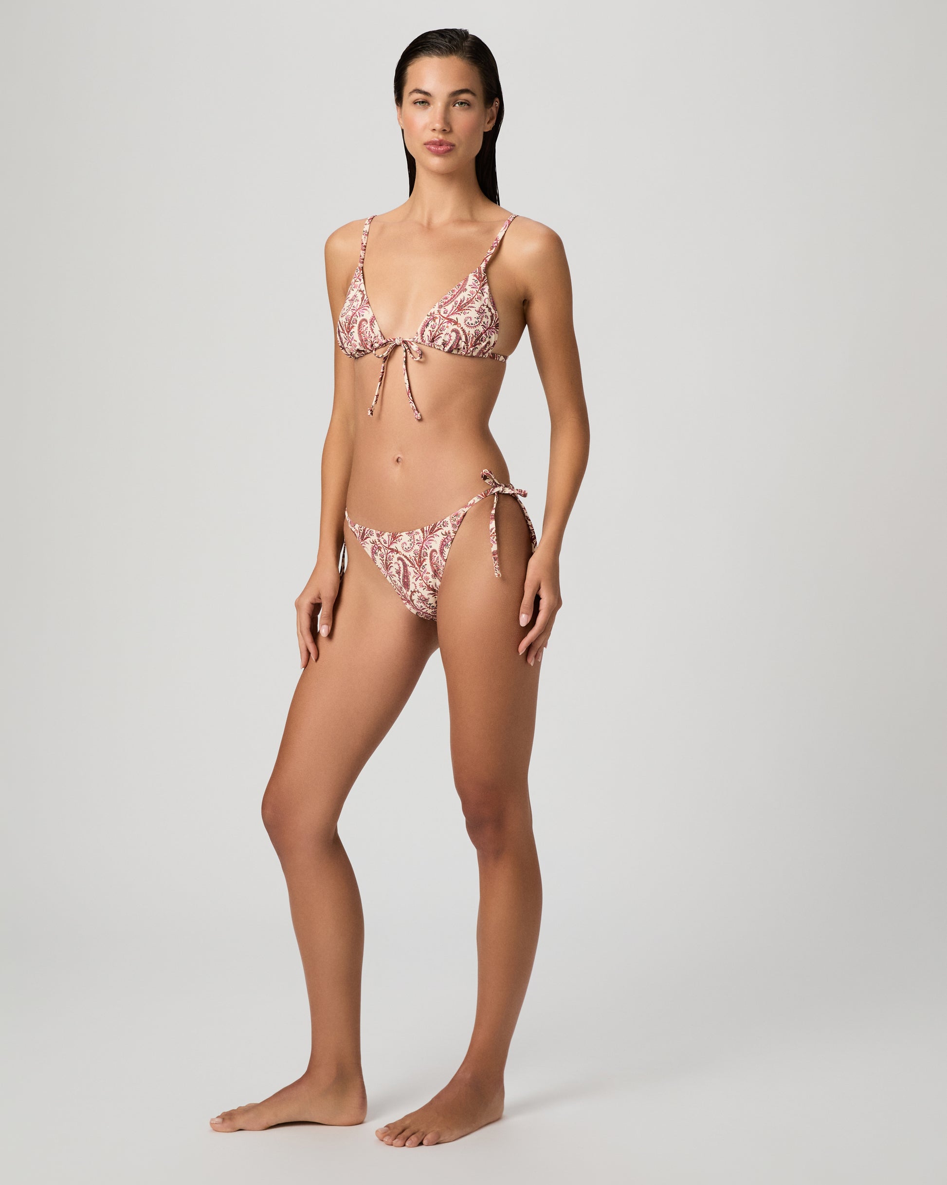 Woman wearing a red and white patterned bikini on a gray background