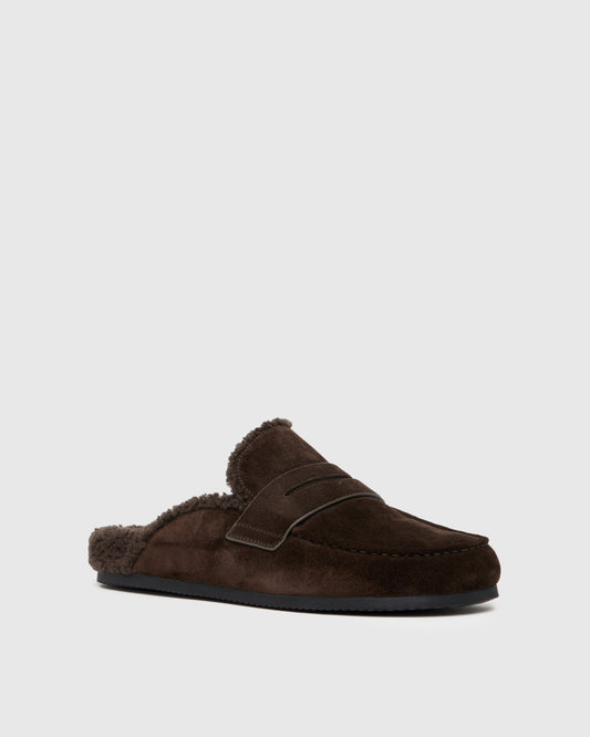 Chocolate color slipper with shearling lining on a light gray background