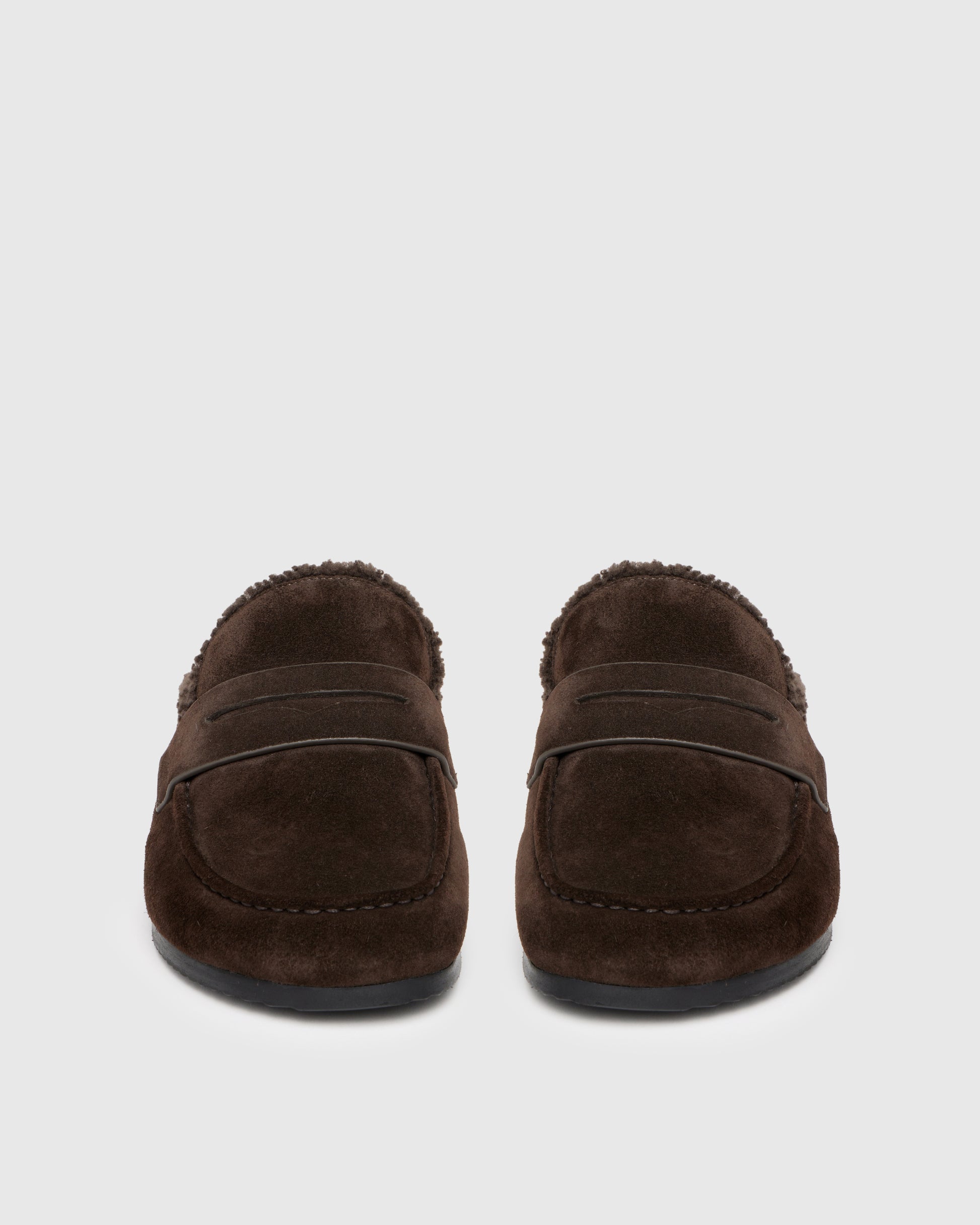 Chocolate color slipper with shearling lining on a light gray background