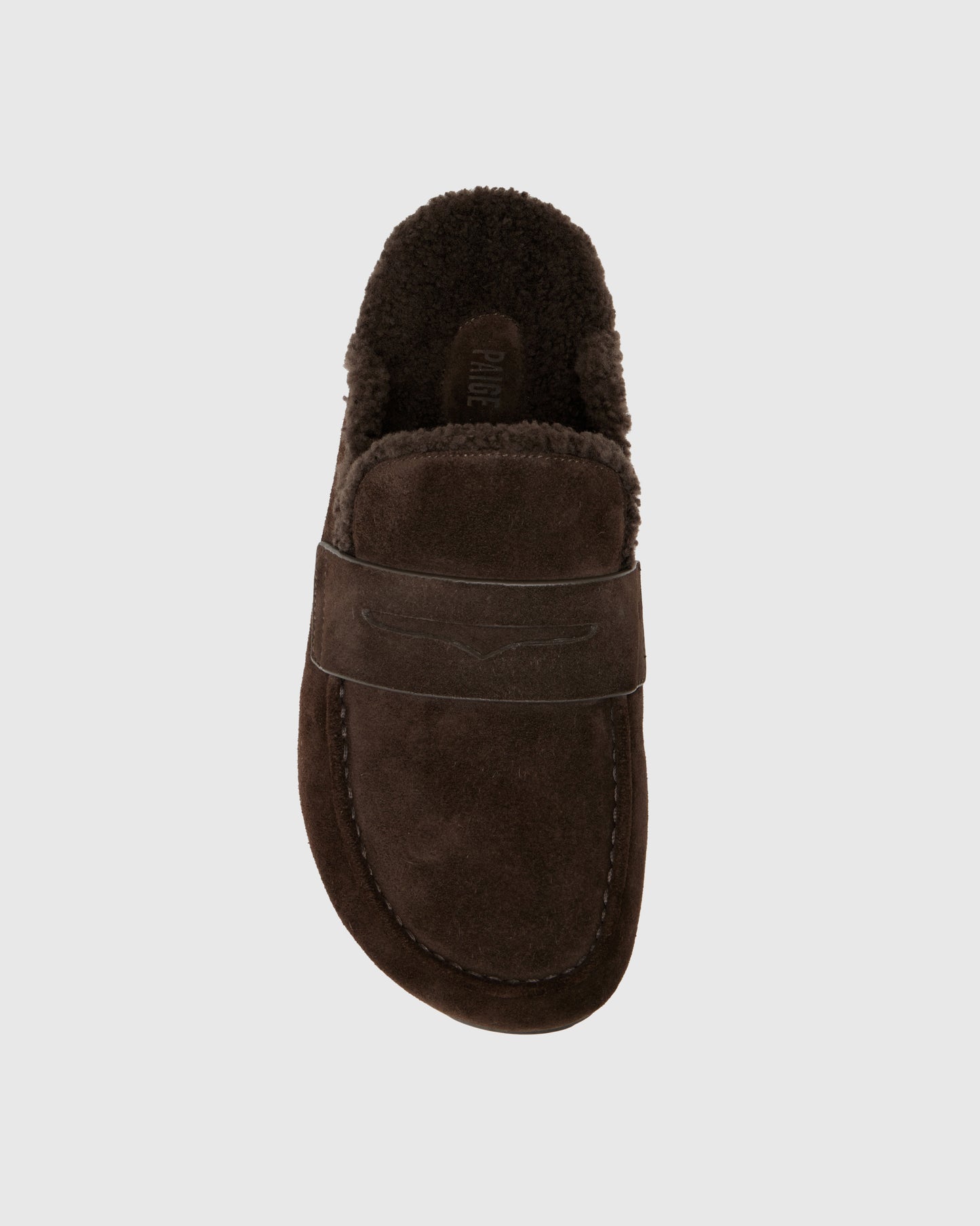 Chocolate color slipper with shearling lining on a light gray background