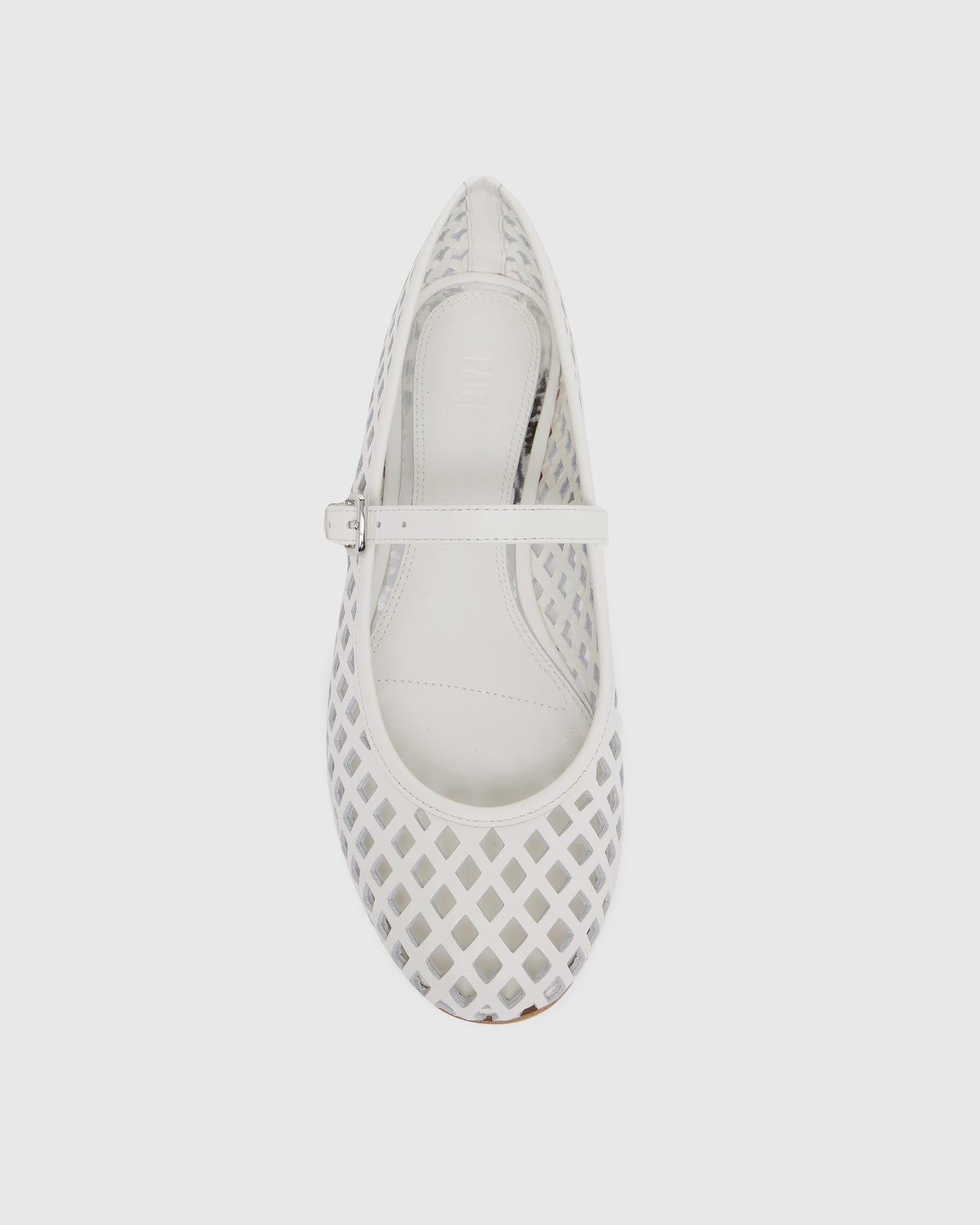 White flat shoe with a strap on a light gray background