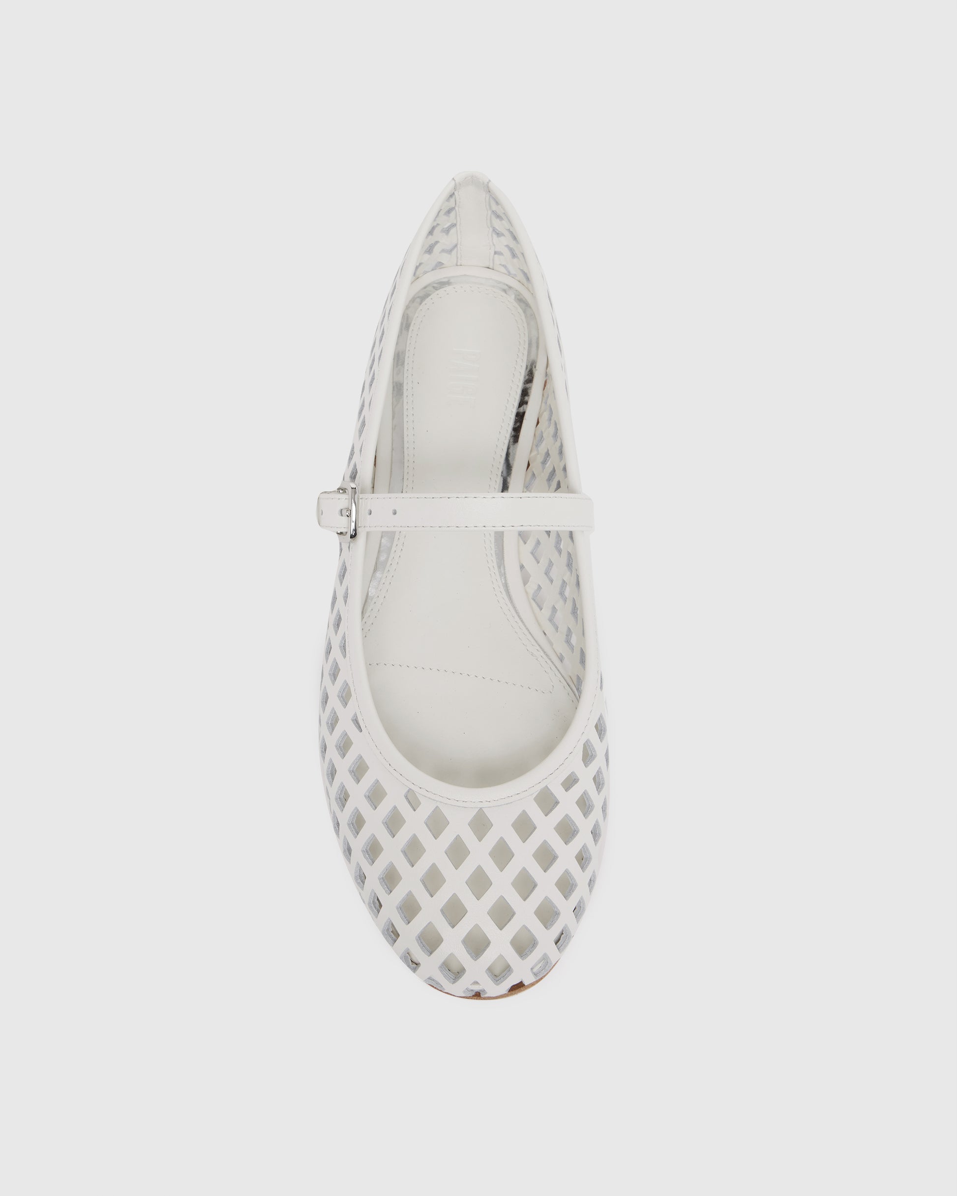 White flat shoe with a strap on a light gray background