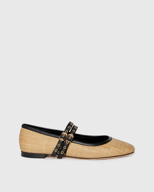 Beige flat shoe with black strap and gold accents on a white background