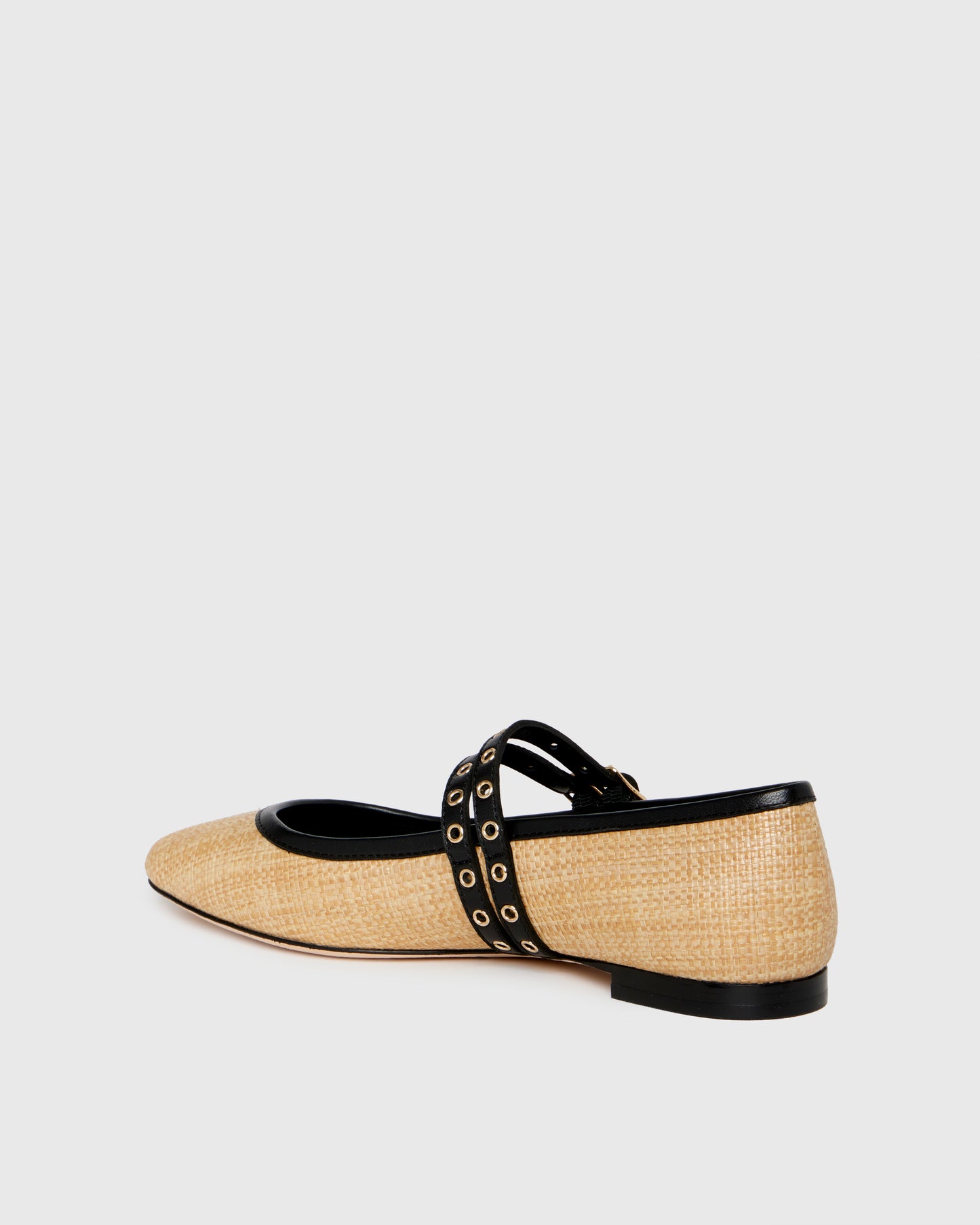Two-tone shoe with straw-like material and black accents on a light gray background