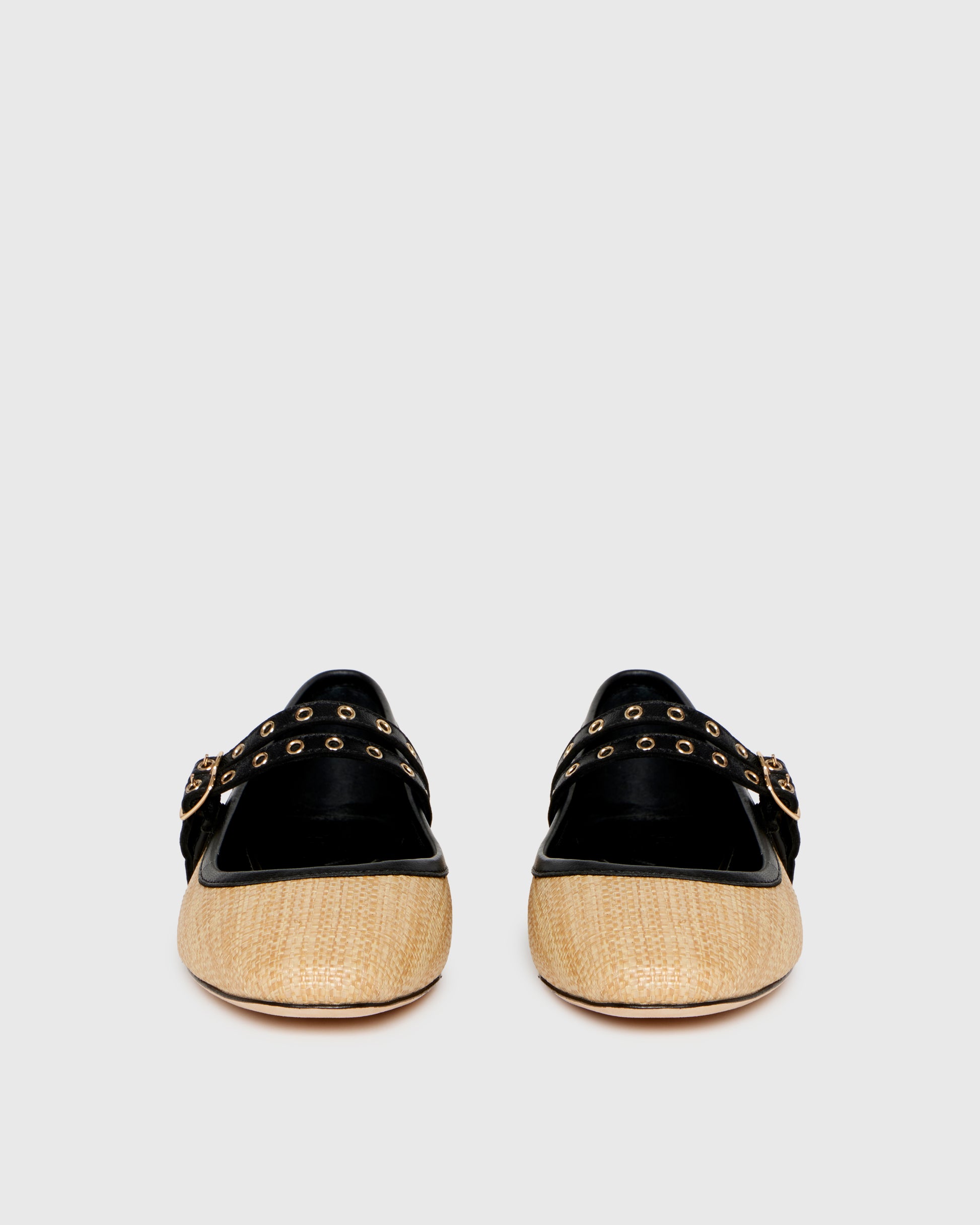 Two-tone shoe with straw-like material and black accents on a light gray background