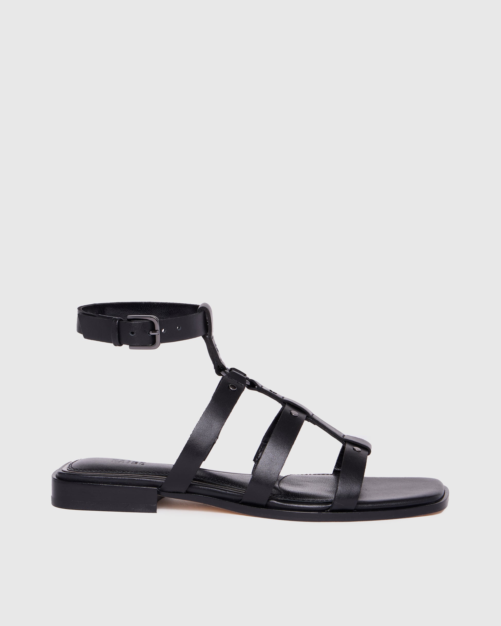 Black sandal with multiple straps on a light gray background