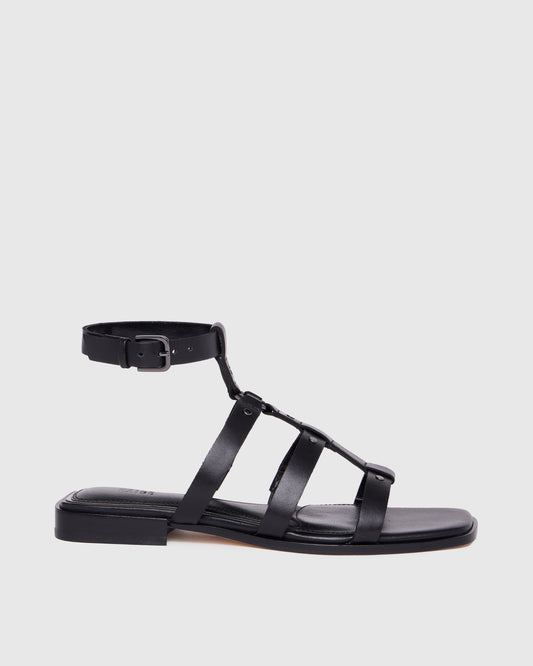 Black sandal with multiple straps on a light gray background