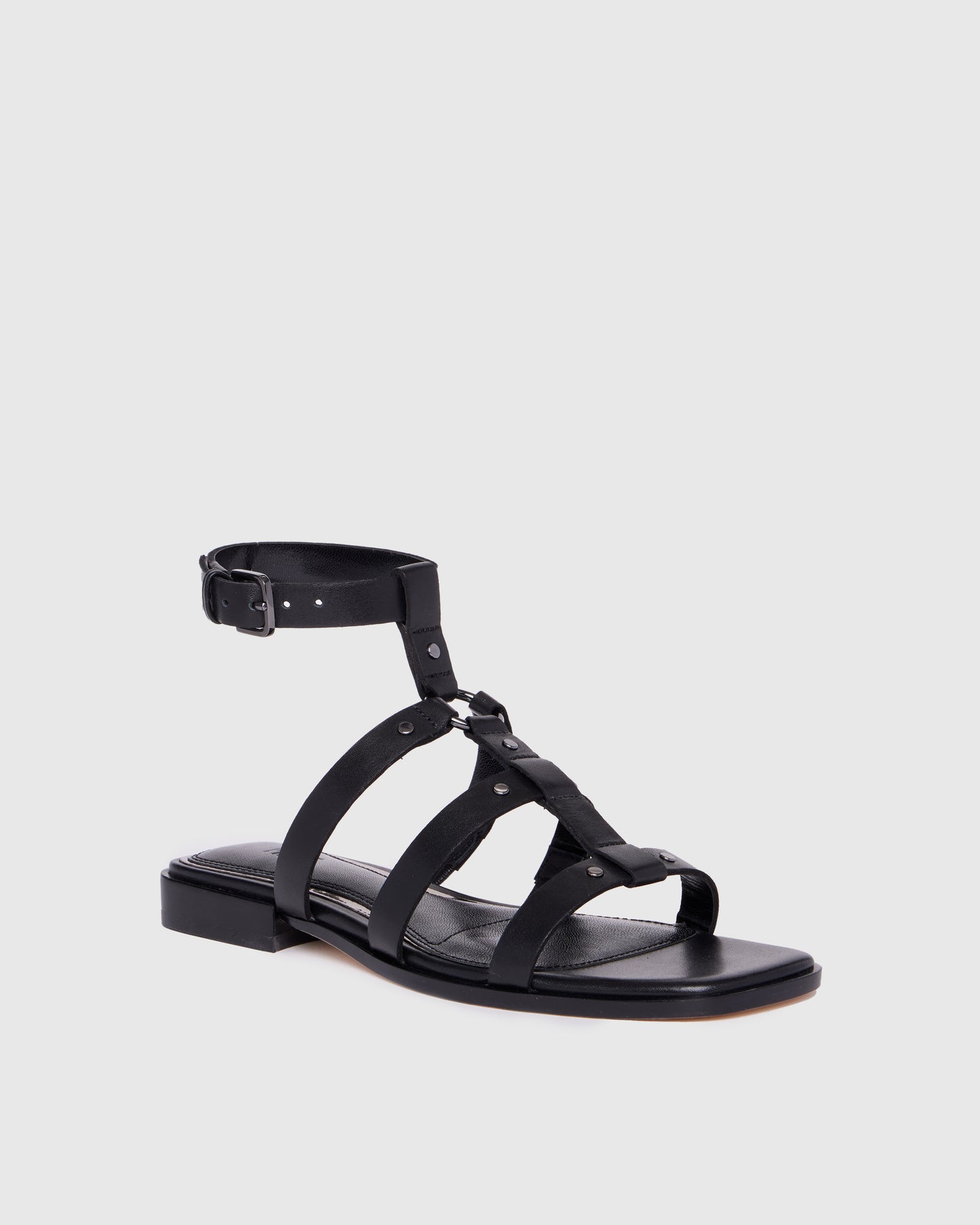Black sandal with multiple straps on a light gray background